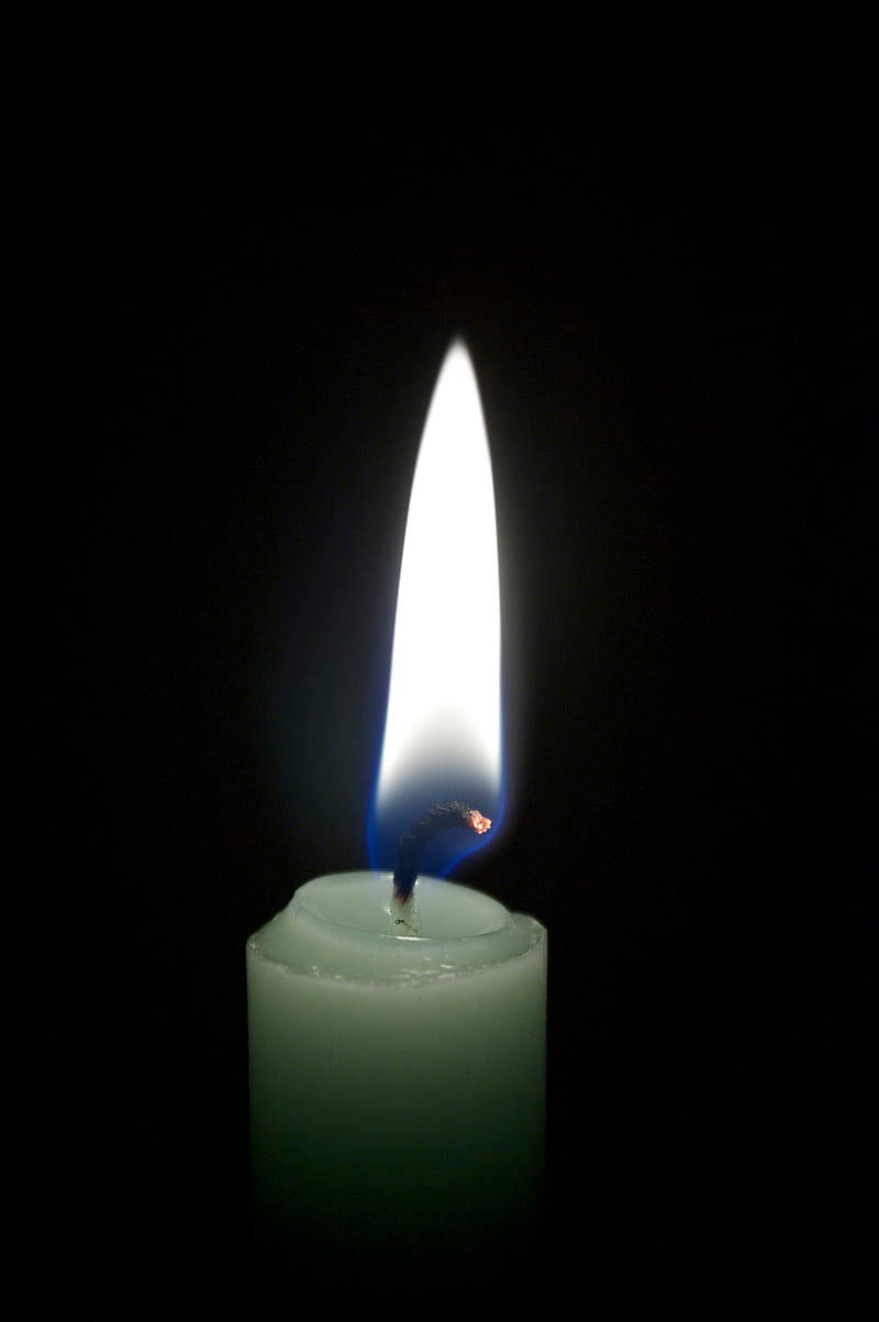 Condolence 桌布 壁紙 — 一支白色蠟燭在漆黑的背景下明亮地燃燒，在蠟燭表面投射出柔和的光芒。