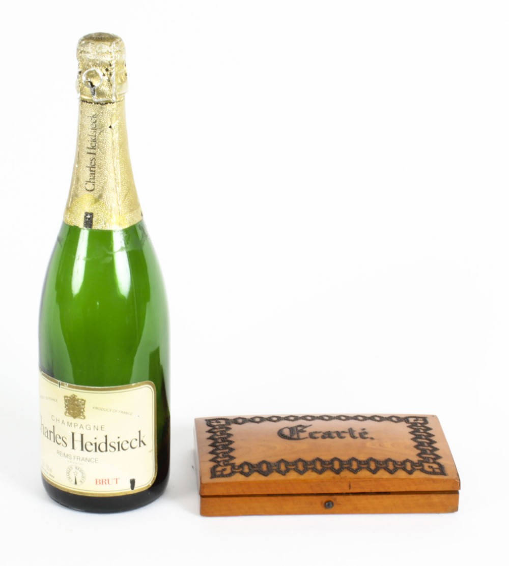 木紋 桌布 壁紙 — 一支綠色 Charles Heidsieck Brut 香檳酒瓶，旁邊放著一個華麗的木製 'Carte' 盒子，背景是純白色。