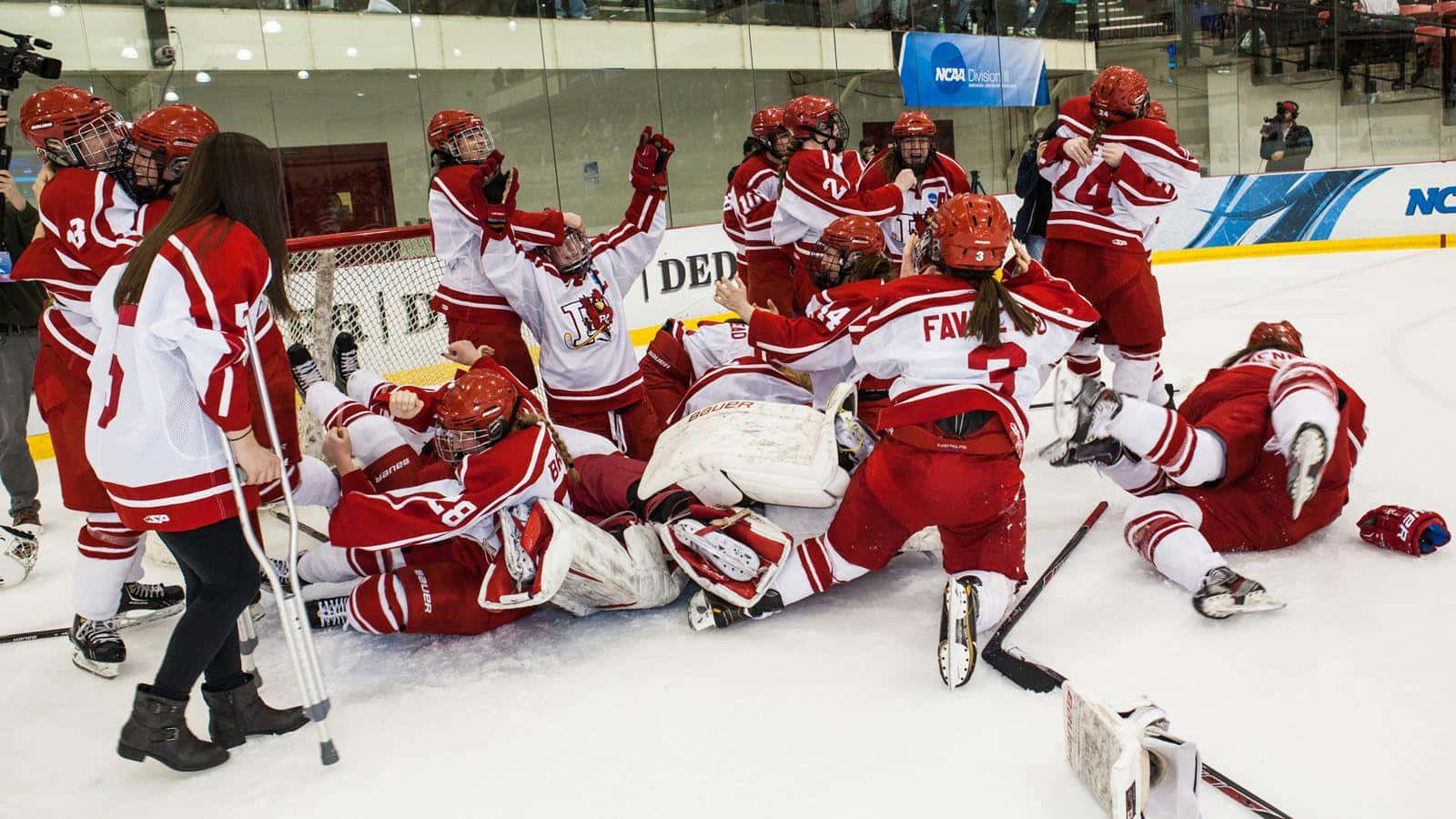 hockey 桌布 壁紙 — 一支身穿紅白球衣、歡欣鼓舞的女子冰上曲棍球隊在冰場上疊羅漢擁抱慶祝進球。