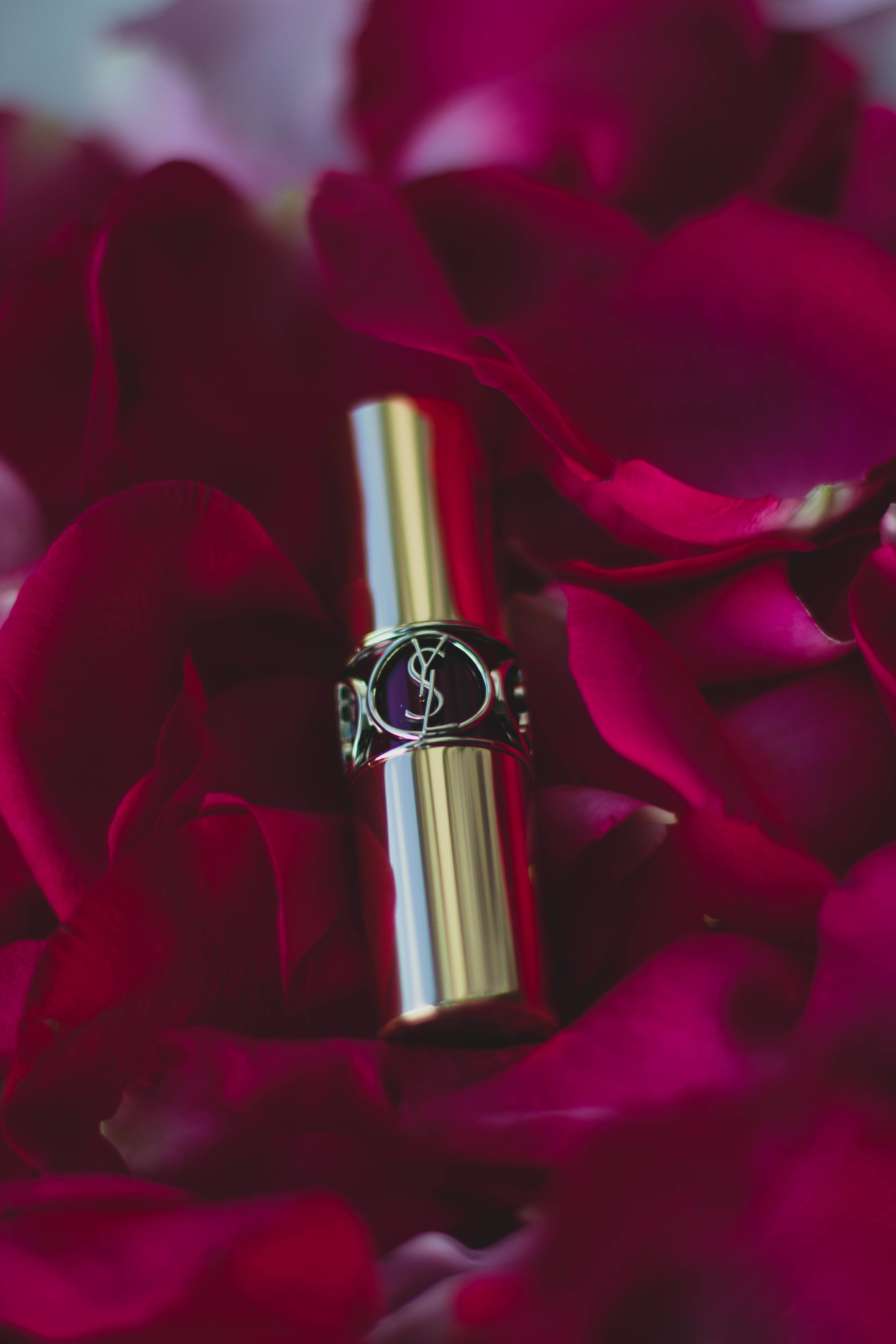 Ysl 桌布 壁紙 — 一支金色YSL唇膏優雅地躺在深紅玫瑰花瓣中，呈現柔焦效果。