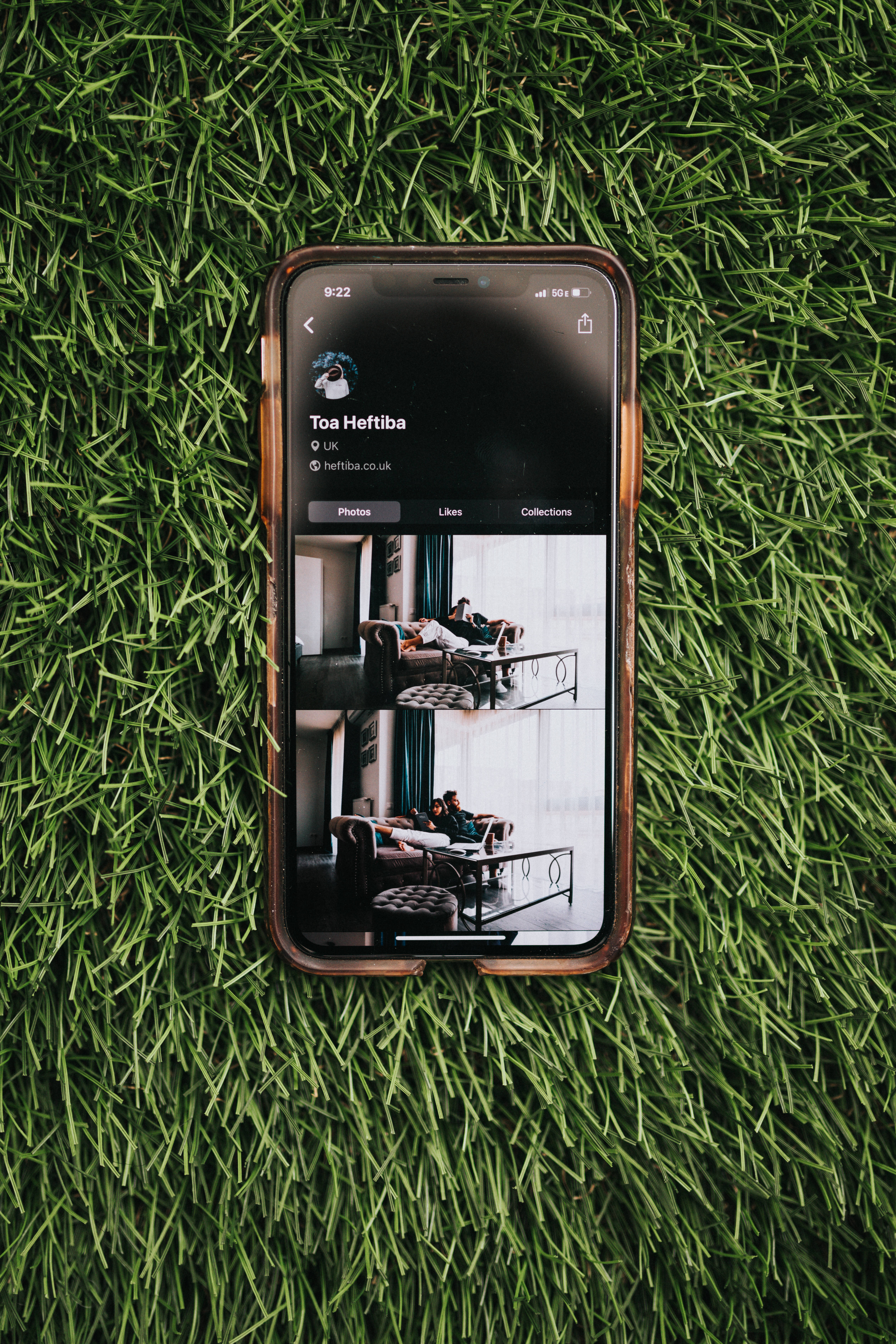 iOS 桌布 壁紙 — 一支顯示Instagram個人資料的智慧型手機放在充滿活力的綠色人造草上。