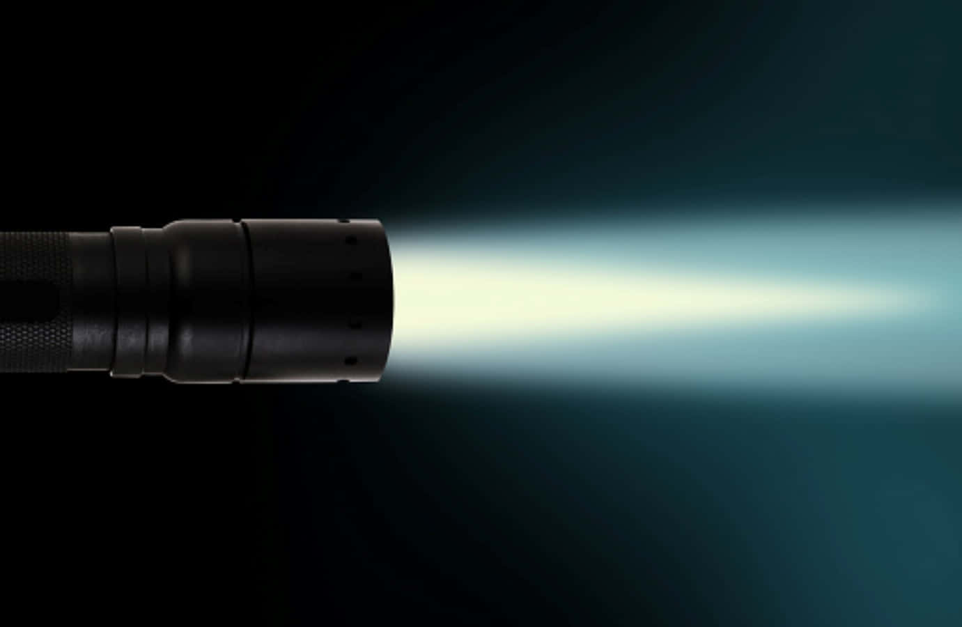 Flashlight 桌布 壁紙 — 一支黑色手電筒在深藍綠色漸層背景上照射出明亮的白光。