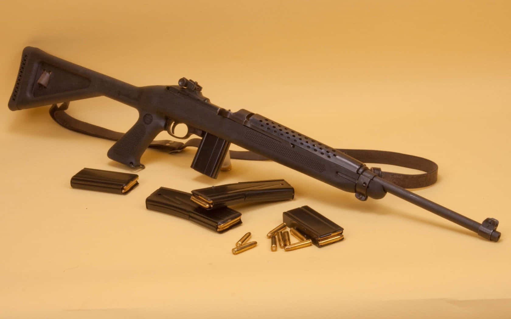 Rifle 桌布 壁紙 — 一支黑色步槍，彈匣和黃銅子彈排列在純米色背景上。