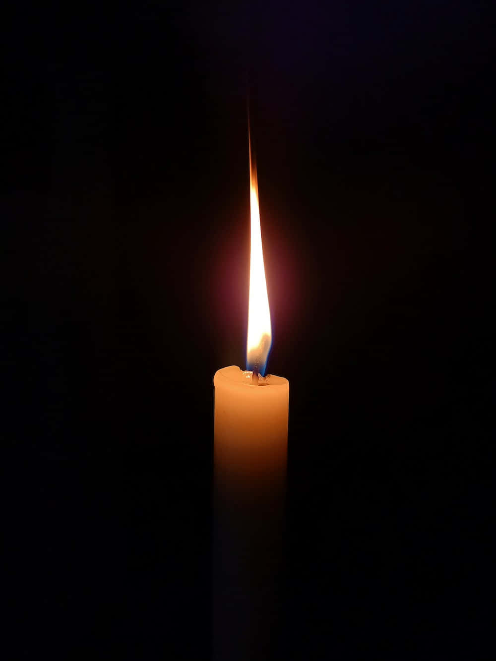Candle Light 桌布 壁紙 — 一支點燃的蠟燭在漆黑背景中散發出溫暖的光芒，營造出寧靜而親密的氛圍。