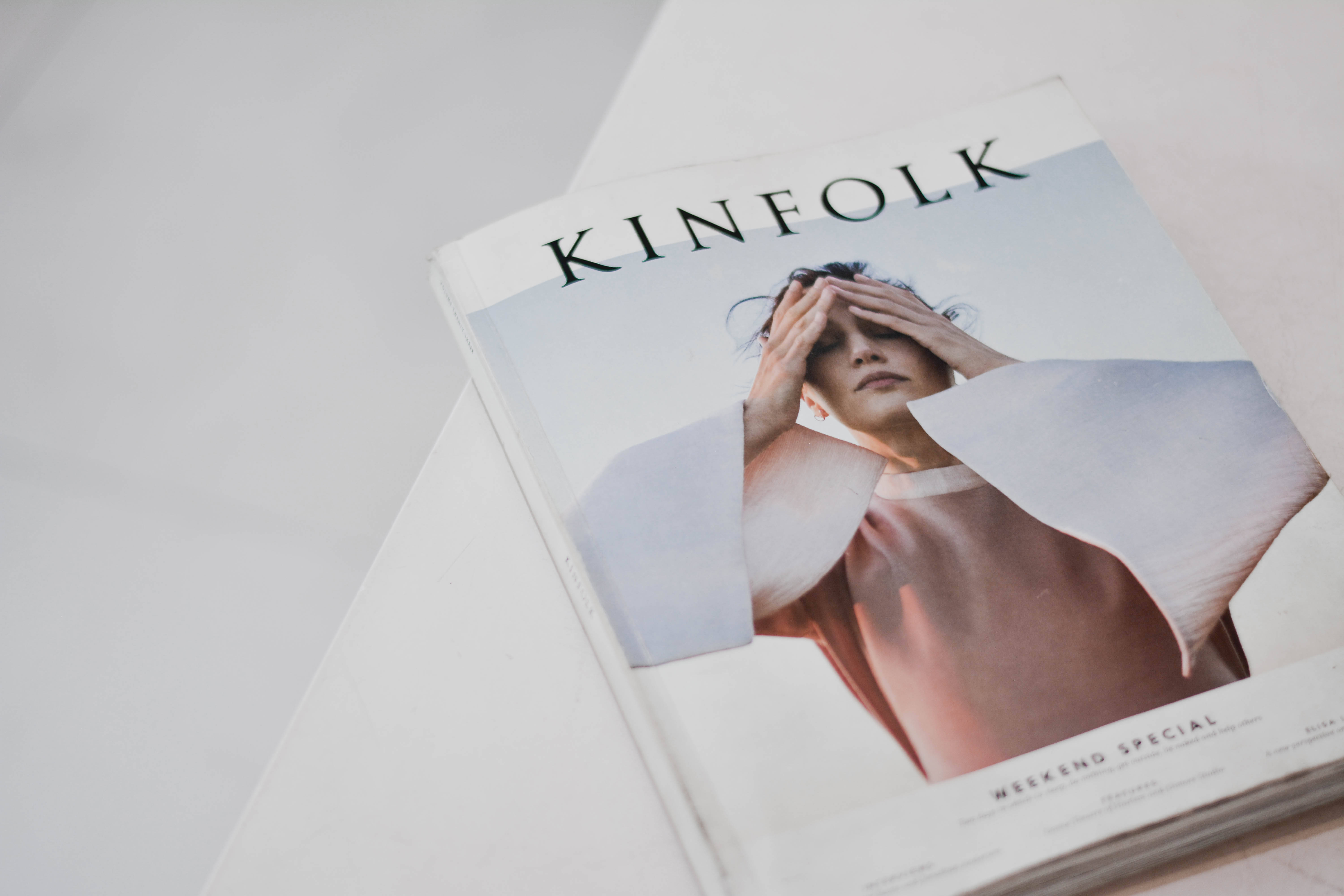 Magazine 桌布 壁紙 — 一本名為 'KINFOLK' 的雜誌，封面有女性遮住眼睛，放在白色表面上。