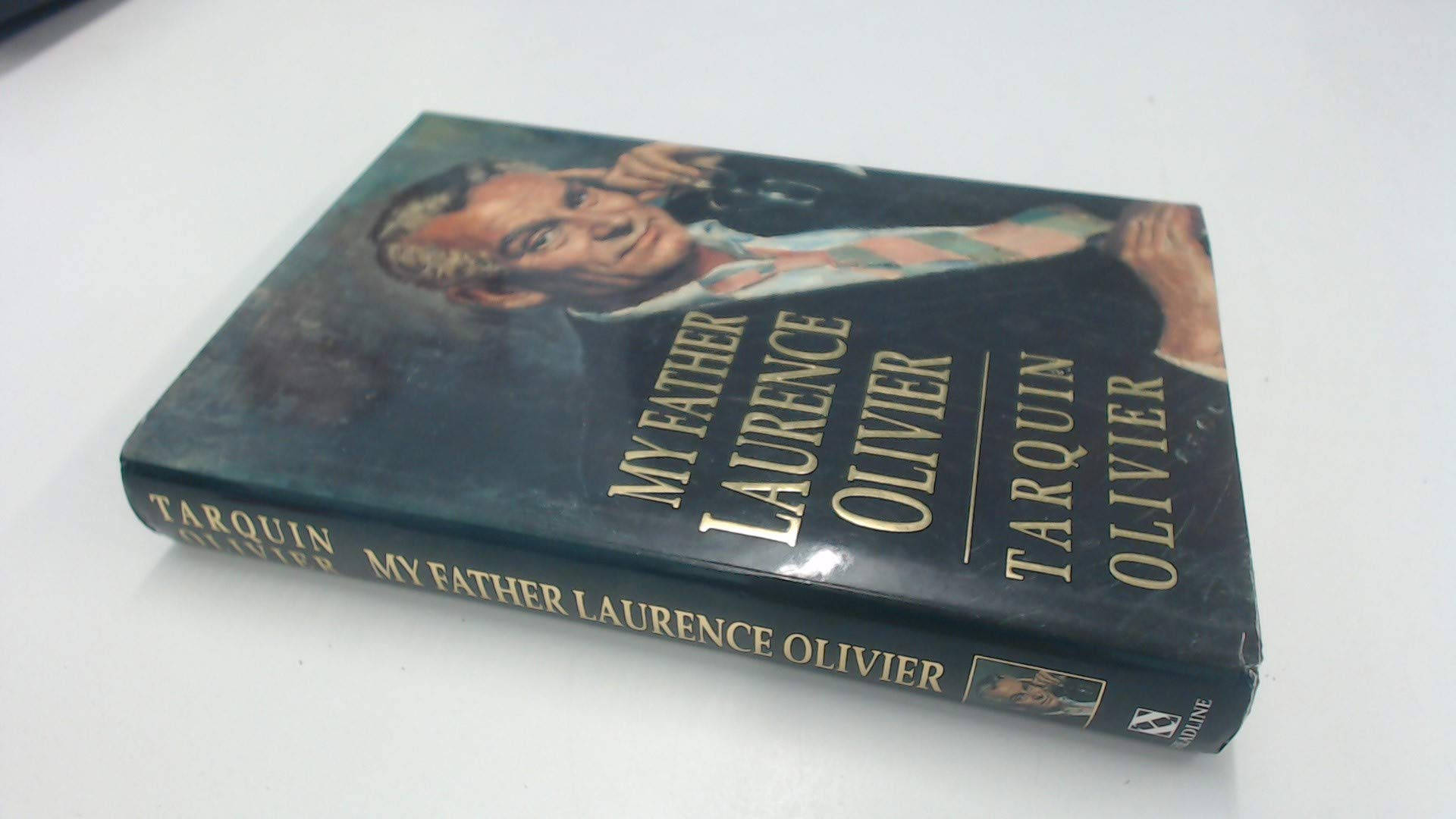 Celebrity 桌布 壁紙 — 一本名為《My Father Laurence Olivier》的復古書，封面有一位男士的肖像，傾斜地放在純白色表面上。