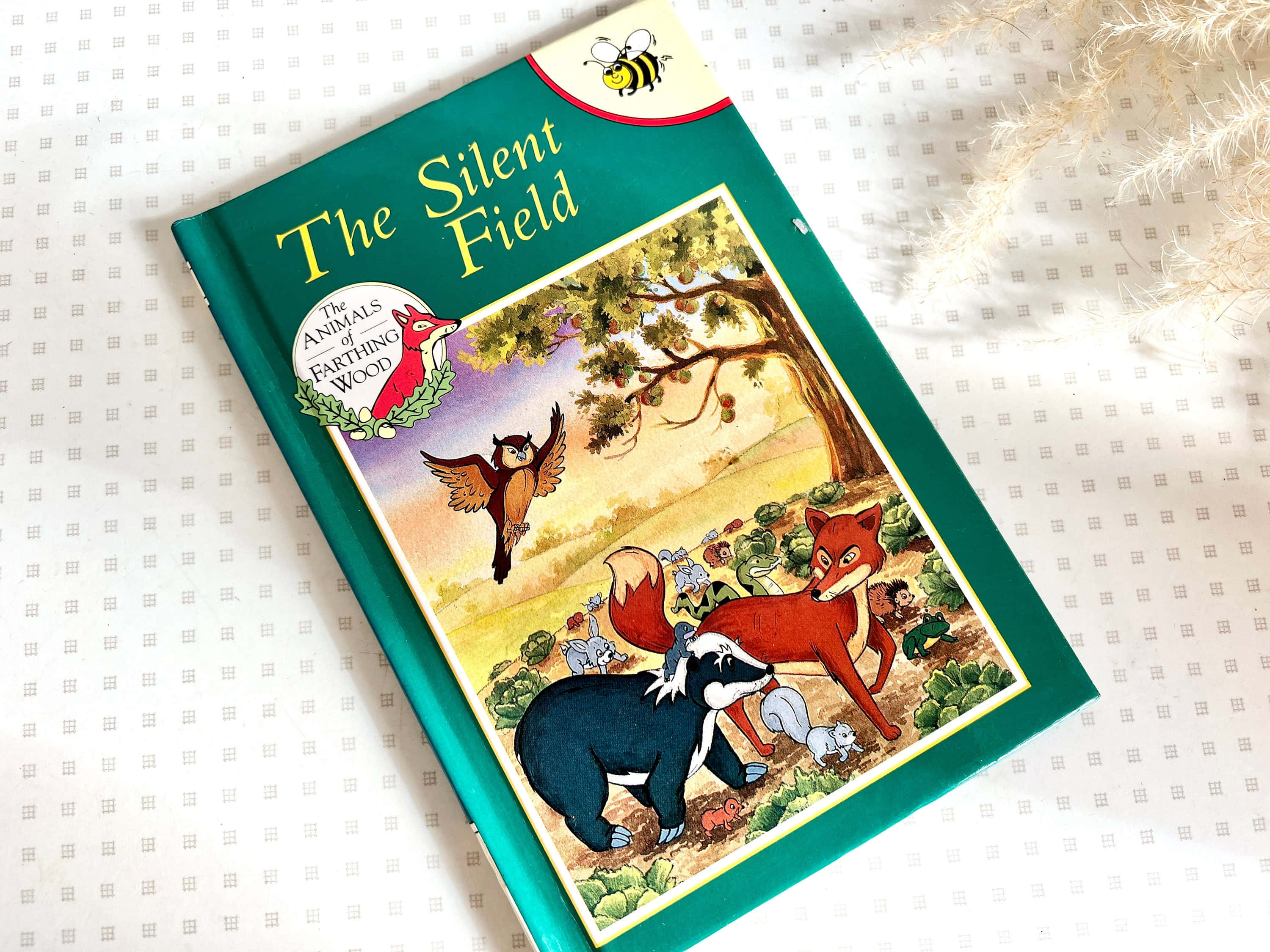 animals 桌布 壁紙 — 一本名為《The Silent Field》的兒童書籍，帶有插圖森林動物，放在有圖案的白色表面上，旁邊有乾草。