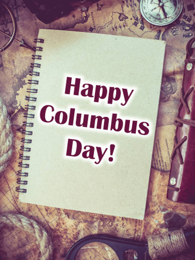 Columbus Day 桌布 壁紙 — 一本復古筆記本，上面寫著「Happy Columbus Day!」，放在一張被指南針和繩索包圍的地圖上。