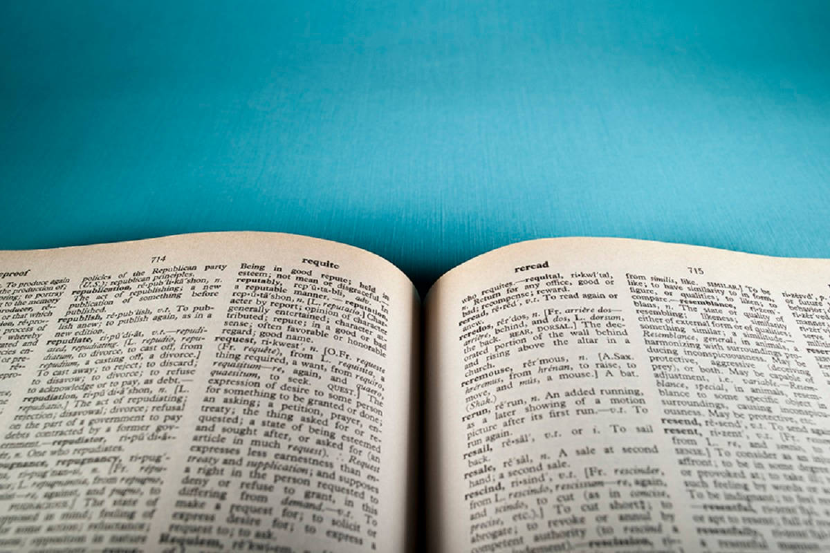 Dictionary 桌布 壁紙 — 一本打開的字典書放在充滿活力的藍色紋理表面上，潔白的頁面顯示著密集的文字。