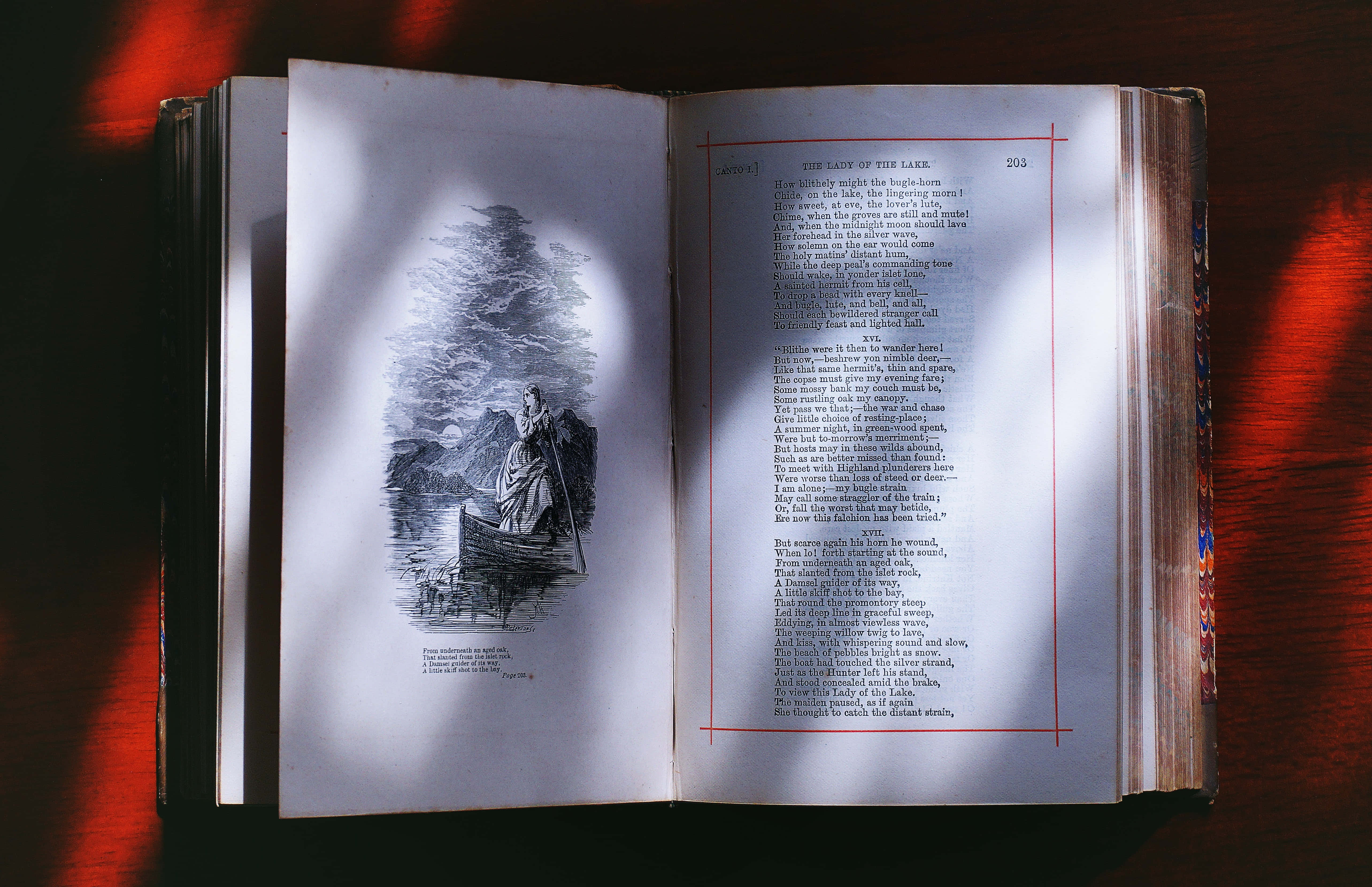 藝術 桌布 壁紙 — 一本打開的復古書籍，內有詳細的黑白插圖，描繪一位女士在湖上的小船中，周圍是泛黃紙張上的文字，背景是溫暖發光的紅色。