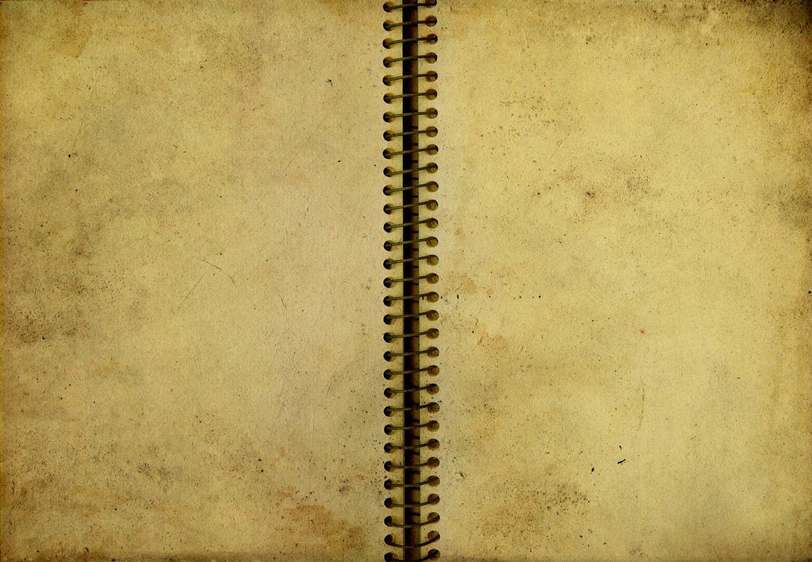 Notebook 桌布 壁紙 — 一本打開的復古螺旋筆記本的近距離特寫，紙張泛黃老舊，有明顯的使用痕跡。