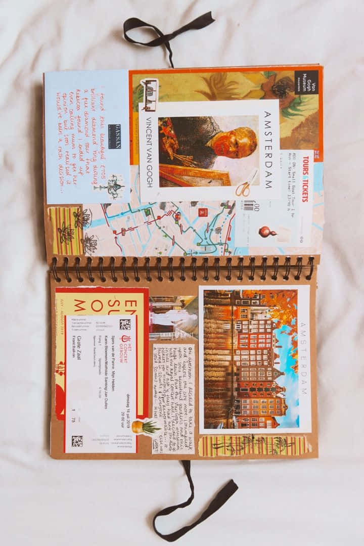 Scrapbooking 桌布 壁紙 — 一本打開的旅行日記，裡面充滿了阿姆斯特丹主題的貼紙、地圖和門票，放在白色床罩上。