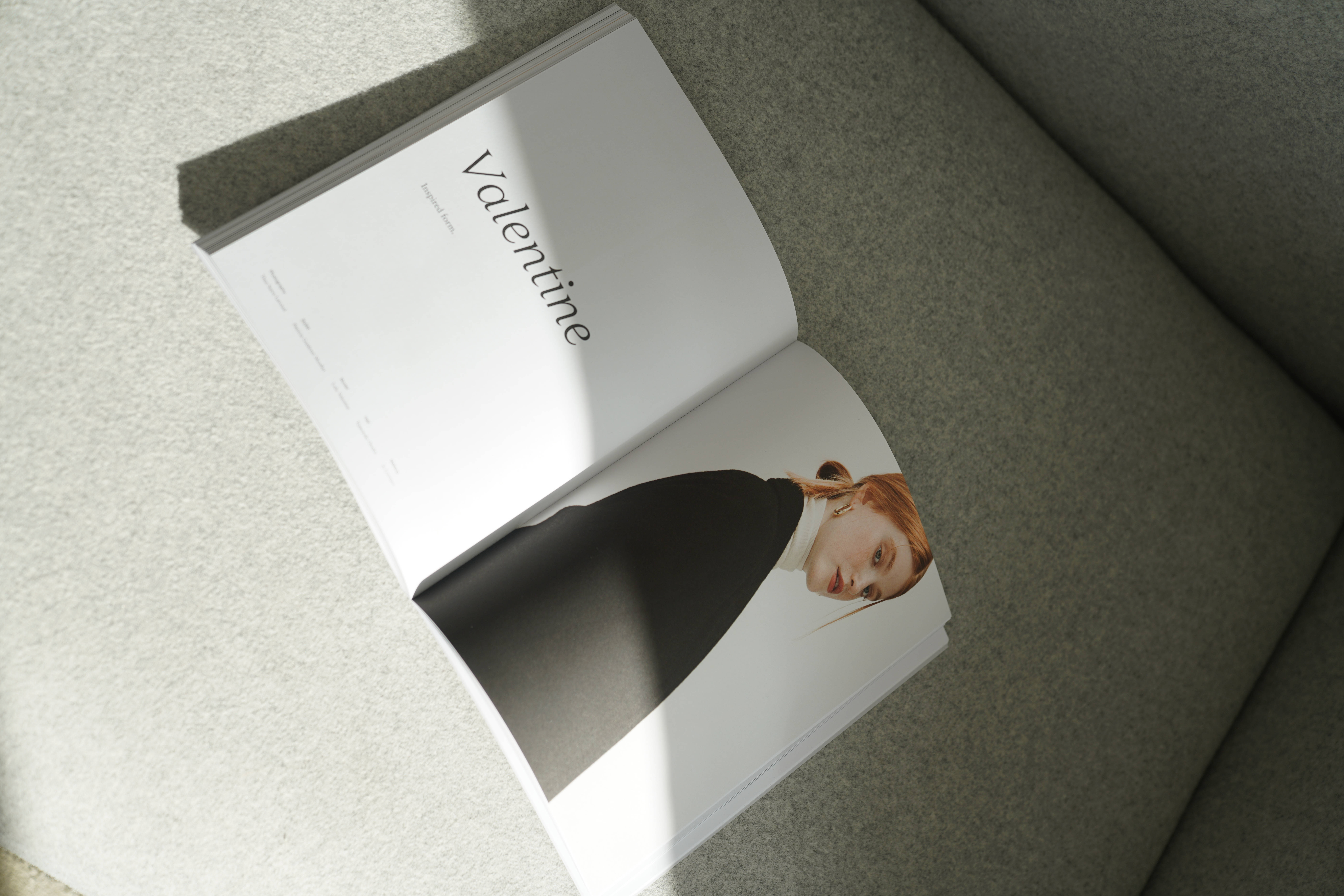 Magazine 桌布 壁紙 — 一本打開的時尚雜誌《Valentine》放在灰色沙發上，柔和自然光投射出陰影。