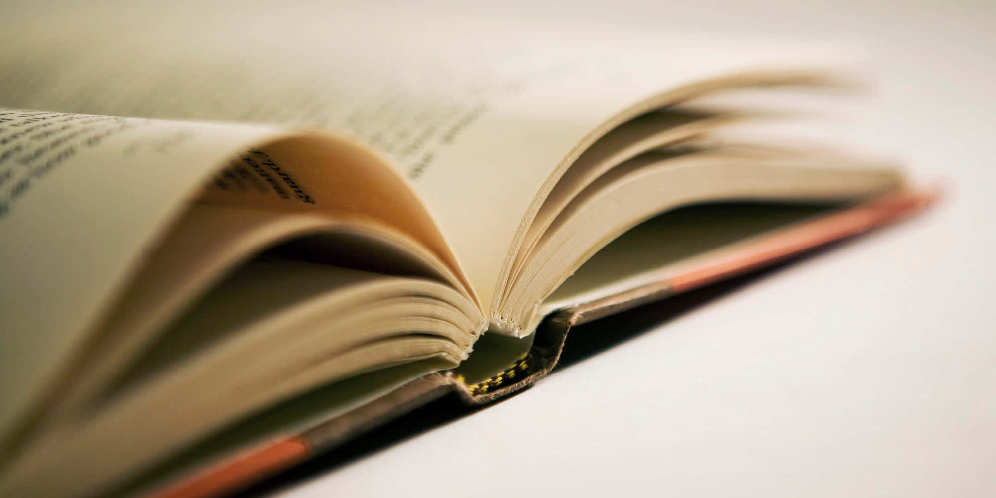 一本打開的書，書上有一片金箔 壁紙