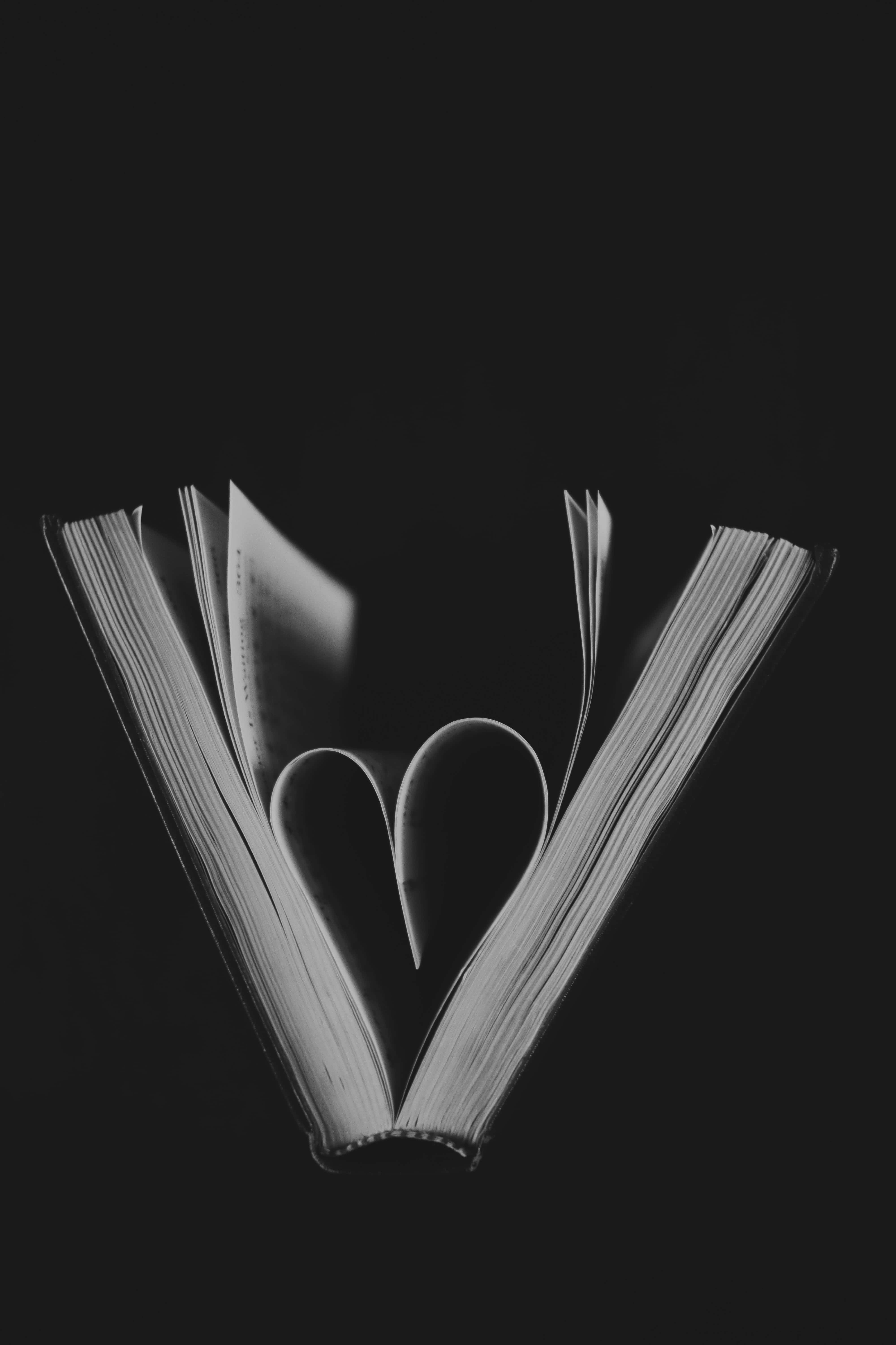 Black And White Heart 桌布 壁紙 — 一本打開的書，書頁摺成心形，襯以單色調的純黑背景。