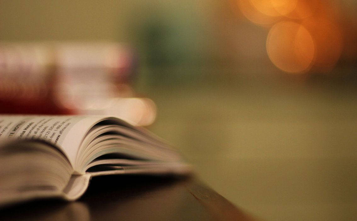 書本 桌布 壁紙 — 一本打開的書放在木質表面上，背景中溫暖的散景燈光柔和地發光。