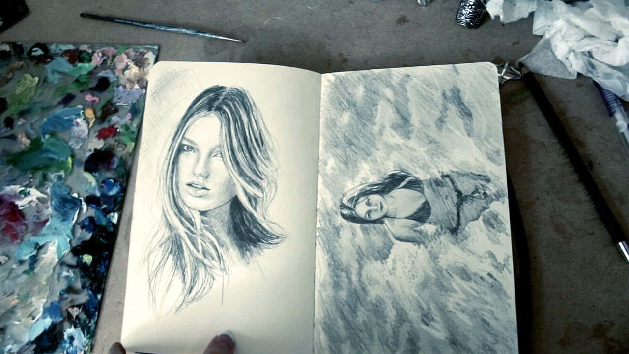 Sketch Art 桌布 壁紙 — 一本打開的素描簿展示兩幅詳細的鉛筆女性肖像，一幅平靜，一幅風暴，周圍環繞著美術用品。