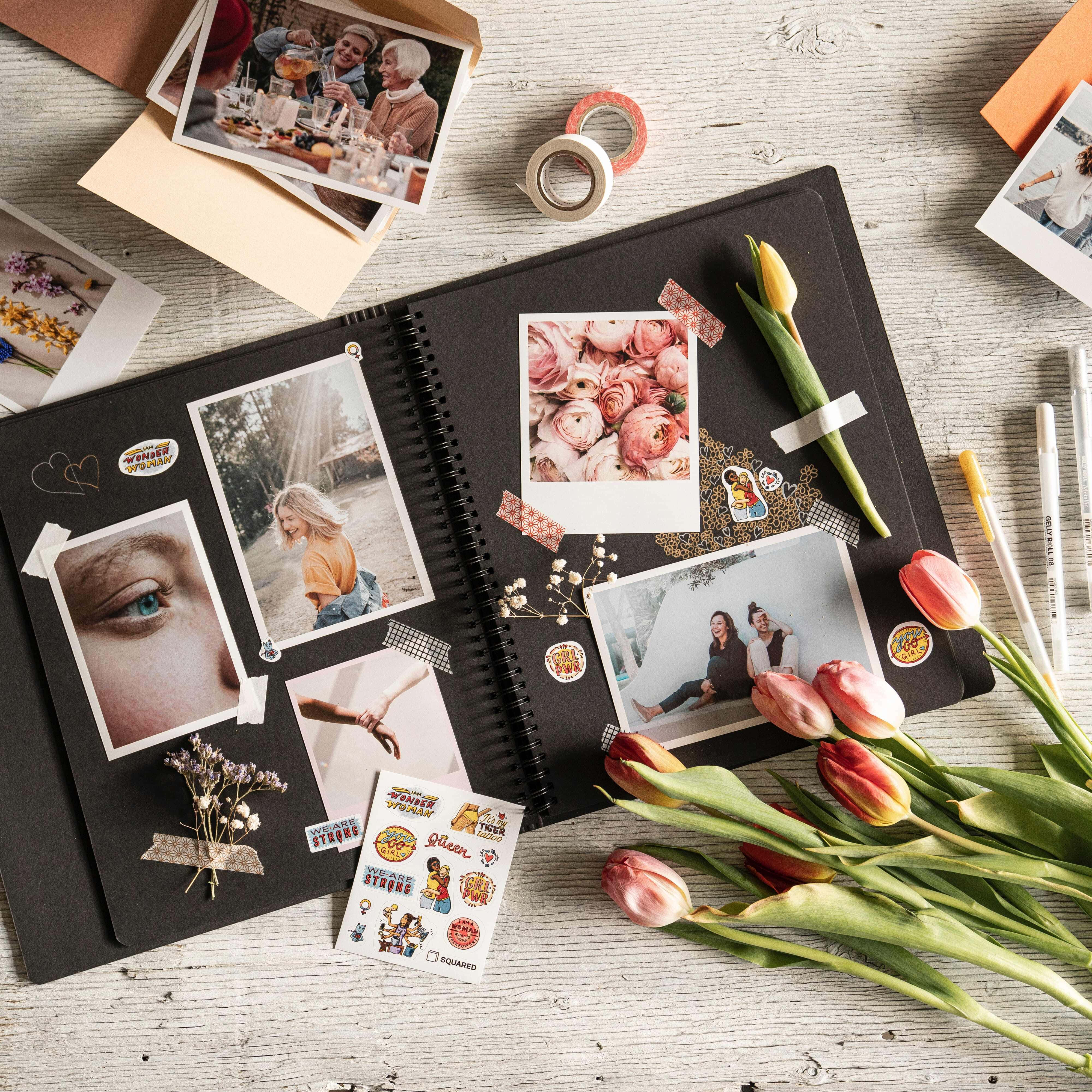 Wedding Album 桌布 壁紙 — 一本打開的黑色剪貼簿，裡面裝滿了照片、貼紙和鬱金香，放在風化的木質表面上。