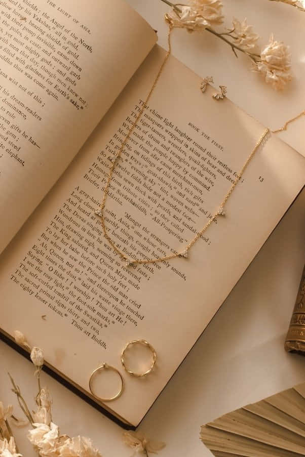 一本放著項鍊與戒指的書 壁紙