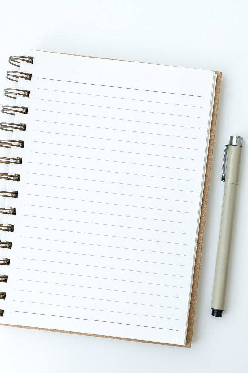 paper 桌布 壁紙 — 一本簡約白色螺旋筆記本，內頁為空白橫線紙張，旁邊放著一支米色筆，置於潔白表面上。