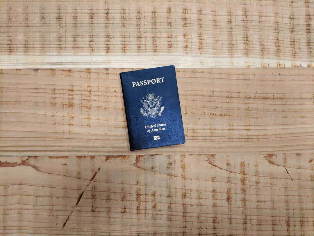 Passport 桌布 壁紙 — 一本美國護照放在帶有天然木紋的紋理木質表面上。