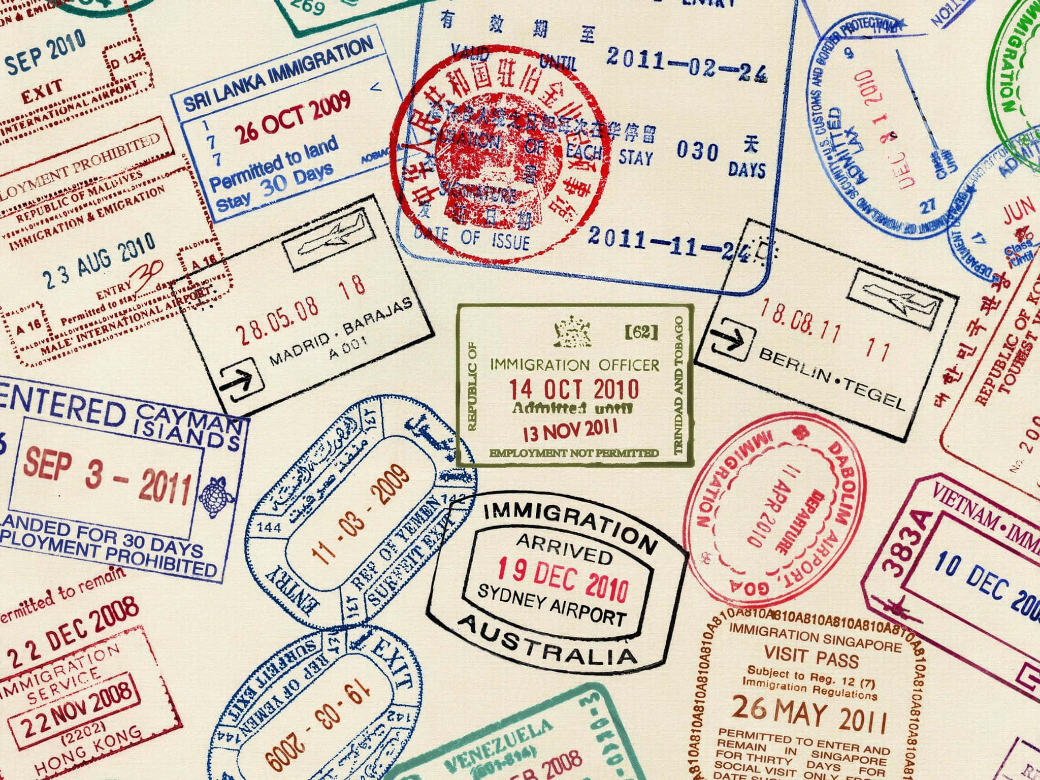 Passport 桌布 壁紙 — 一本護照頁的特寫，上面佈滿來自不同國家和日期的彩色國際入境印章。