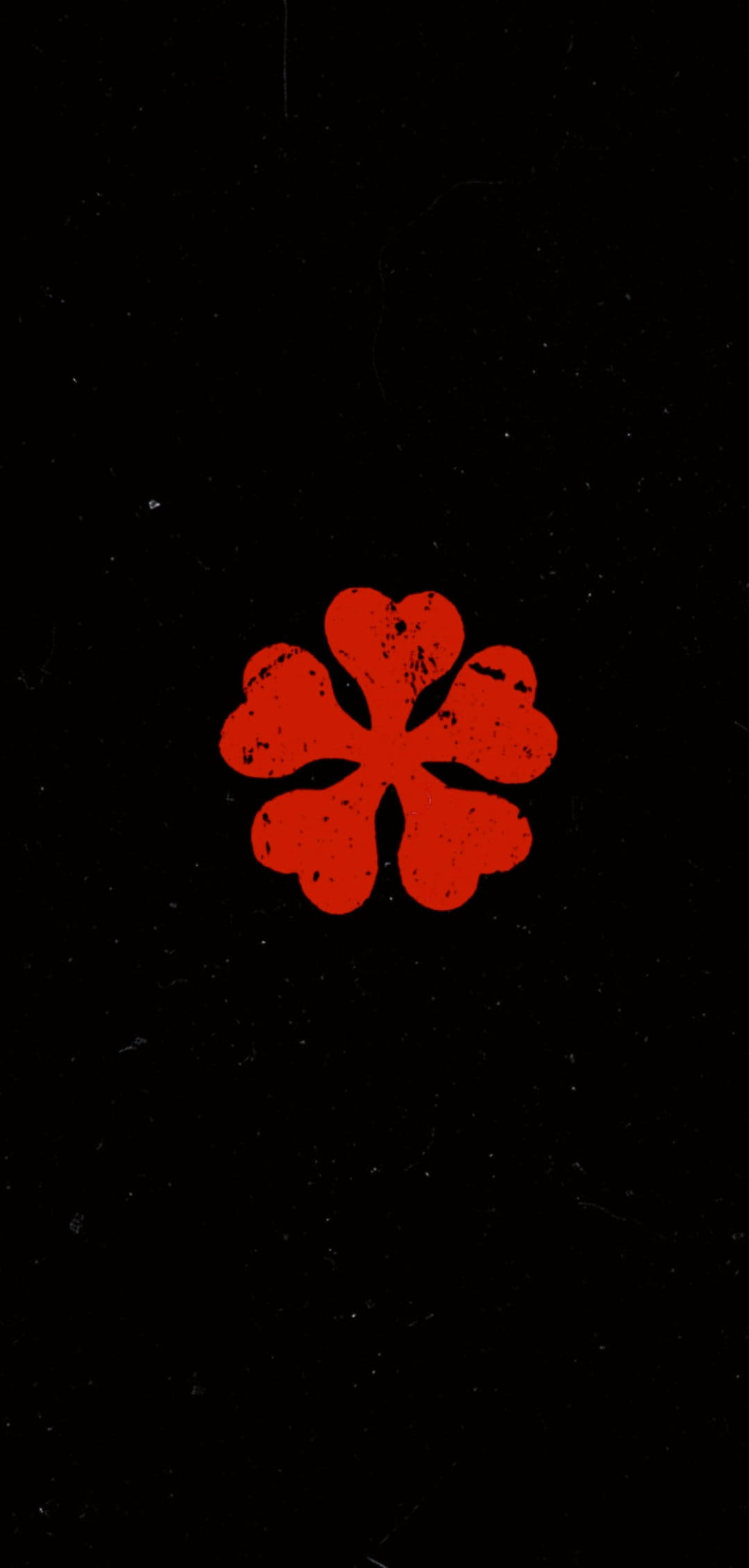 黑色動畫gif 桌布 壁紙 — 一朵大膽的紅色四瓣花，帶有磨損質感，居中在帶有斑點的黑色背景上。