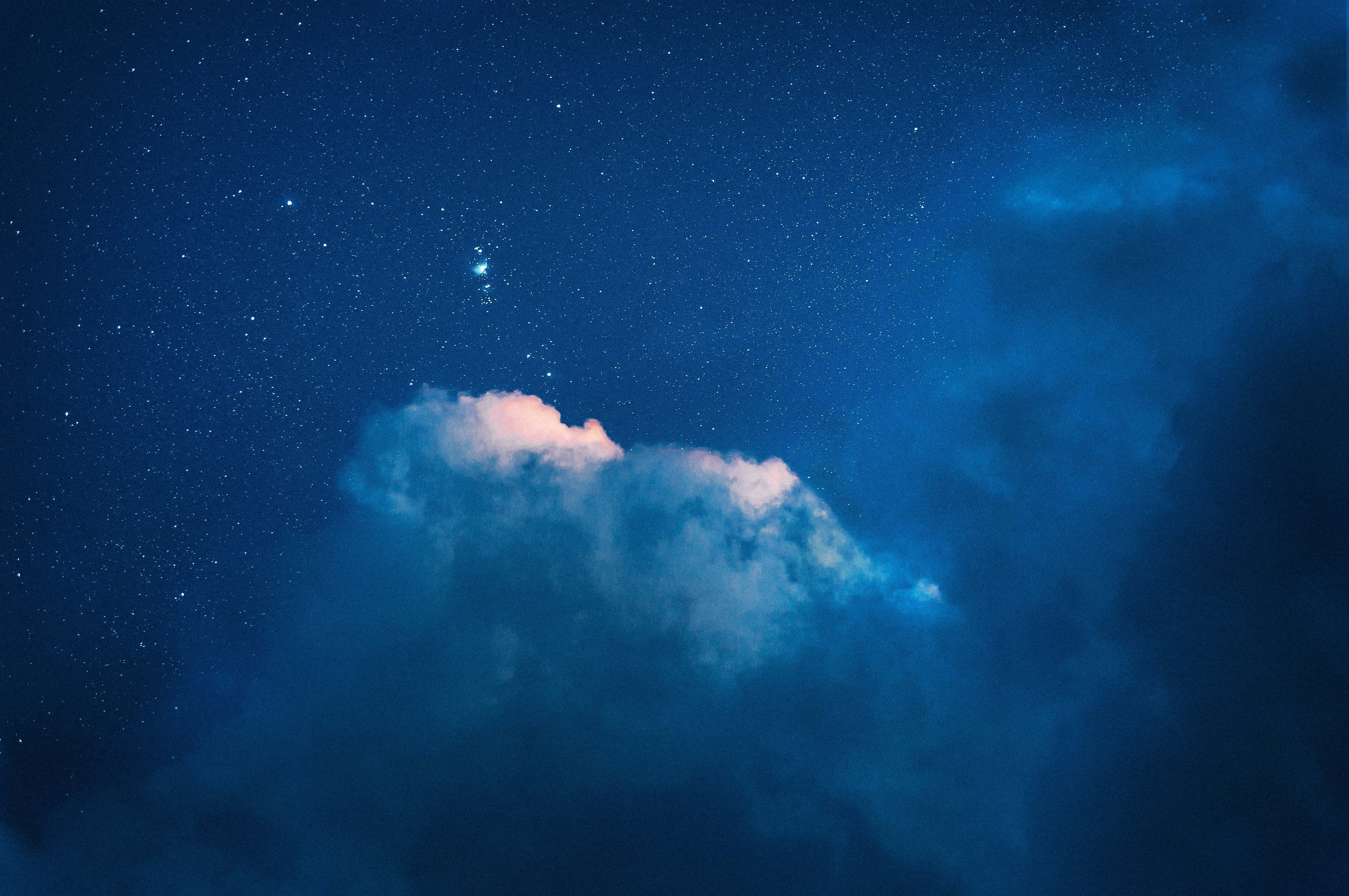 夜空 桌布 壁紙 — 一朵孤獨的雲在深藍色和粉紅色調的星空夜空中柔和地發光。