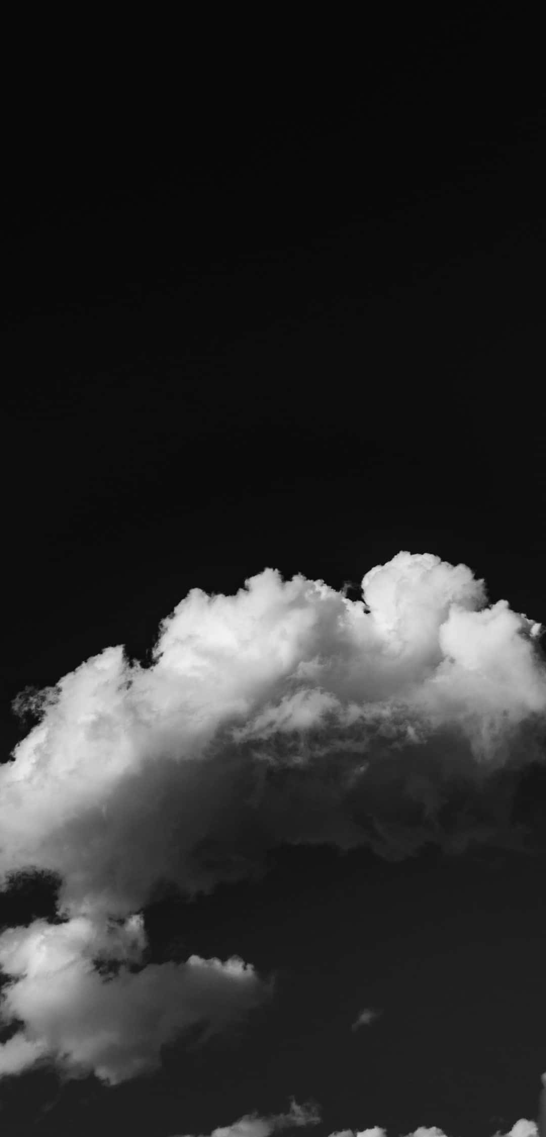 自然 桌布 壁紙 — 一朵戲劇性的雲朵漂浮在深邃的黑色天空中，呈現高對比度的單色效果。