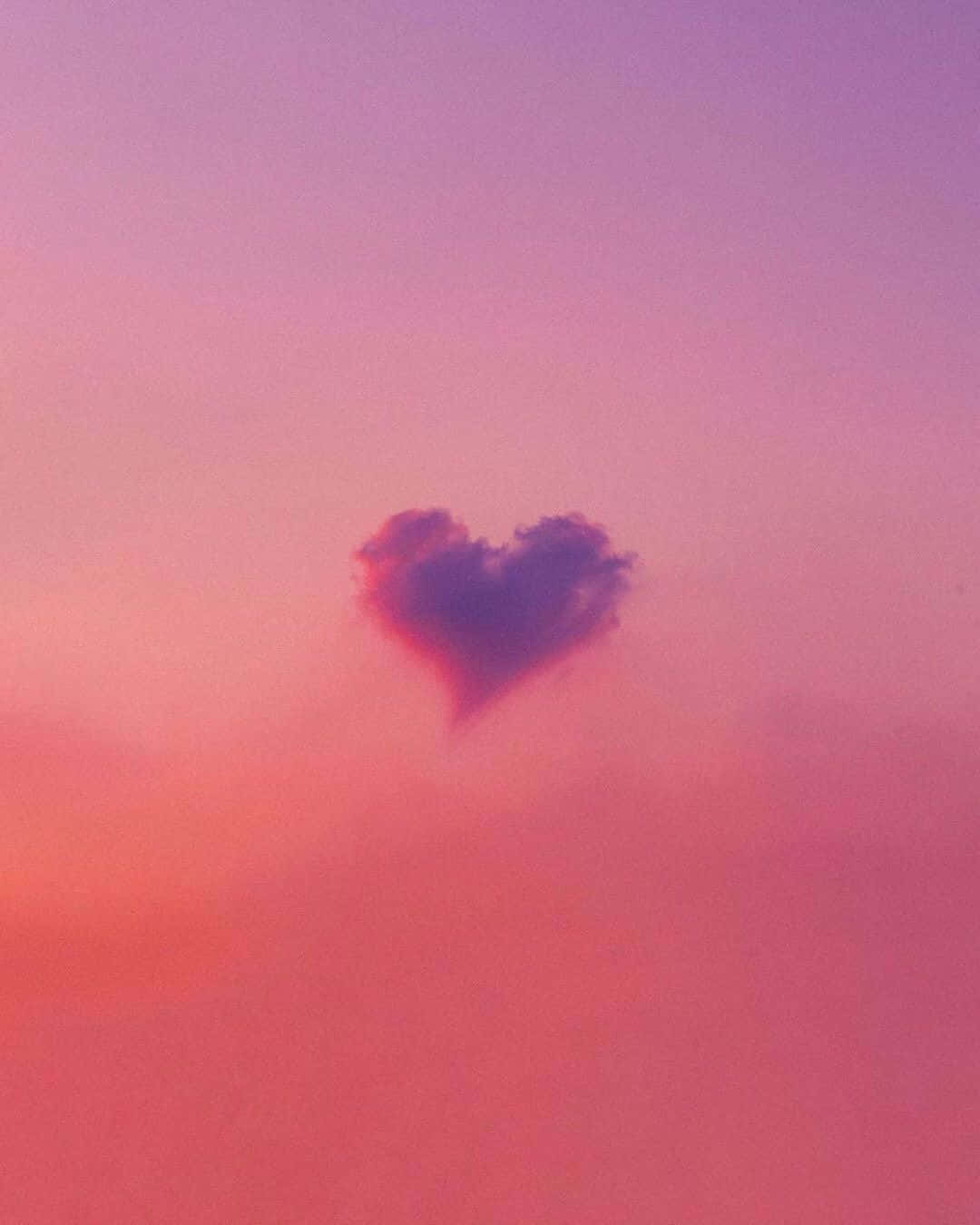 Heart Shape 桌布 壁紙 — 一朵柔軟的心形雲朵漂浮在夢幻的粉紅與紫色暮色天空中。