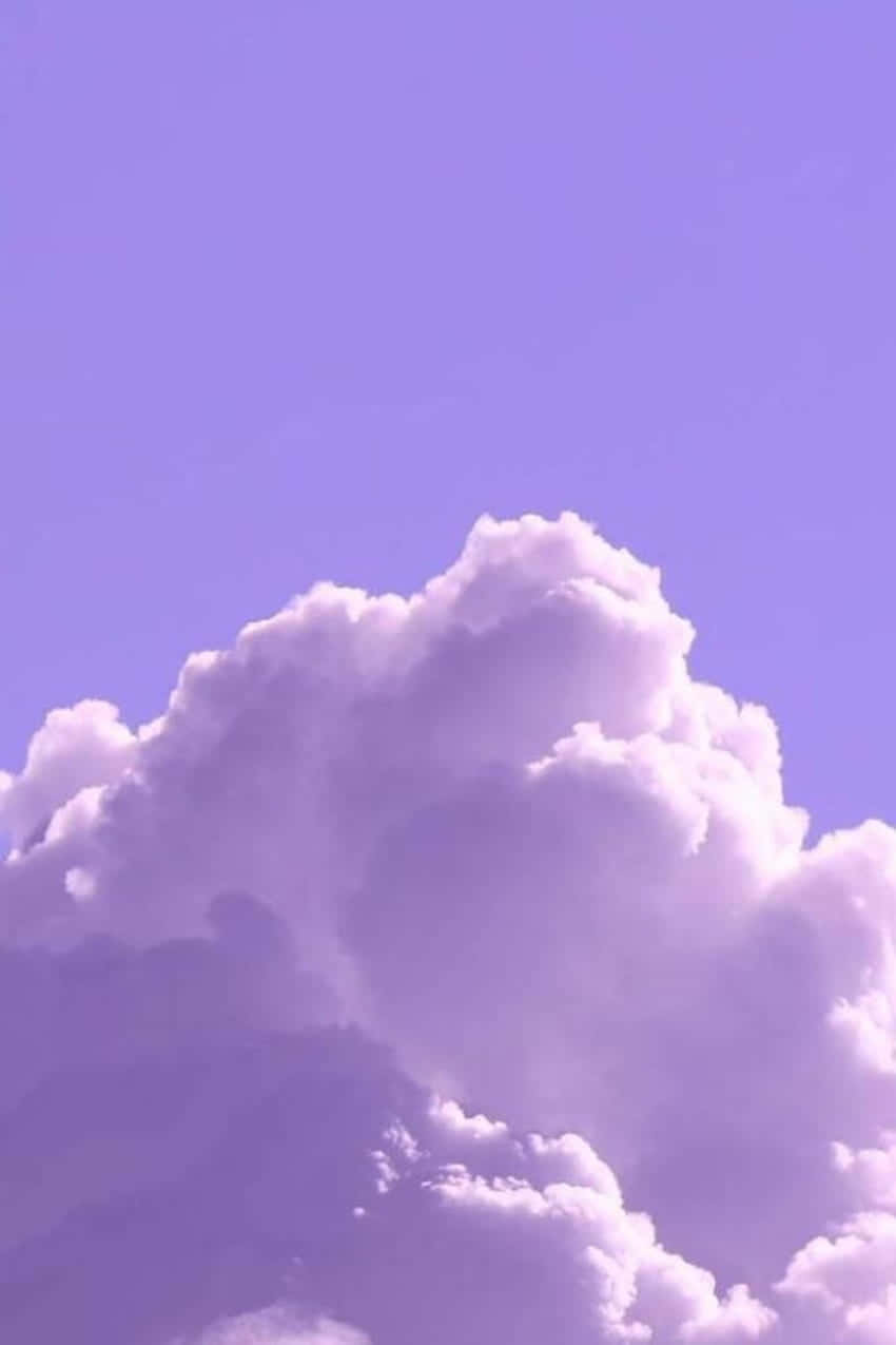 Aesthetic Purple 桌布 壁紙 — 一朵蓬鬆的白雲主宰著柔和的薰衣草色天空，營造出夢幻的粉彩氛圍。