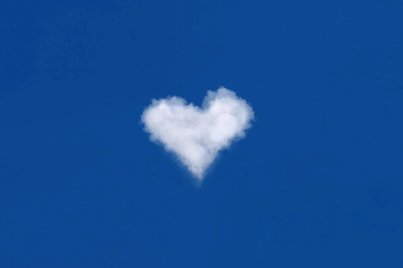 Blue Heart 桌布 壁紙 — 一朵蓬鬆的白雲呈心形，在湛藍的天空中寧靜地飄浮。