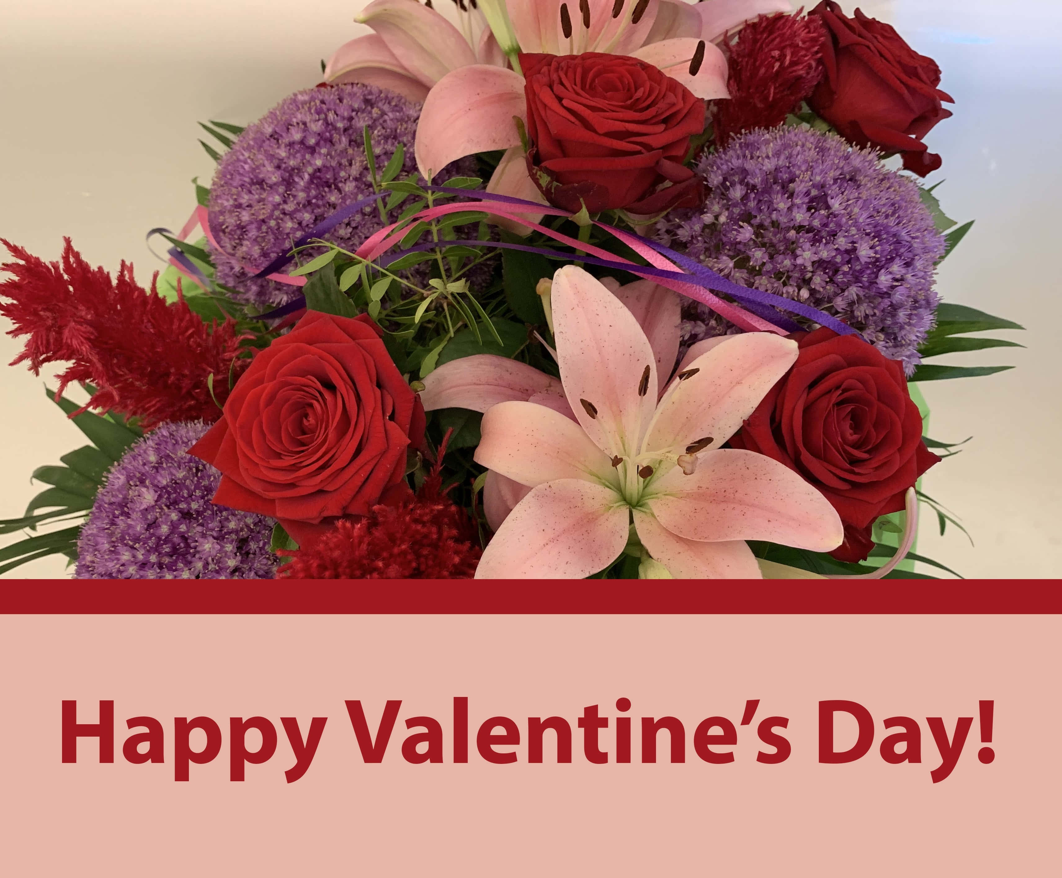 Valentine's Day 桌布 壁紙 — 一束充滿活力的情人節花束，包含紅玫瑰、粉紅百合、紫色蔥花和紅色羽毛狀花朵，並以紫色絲帶捆紮。