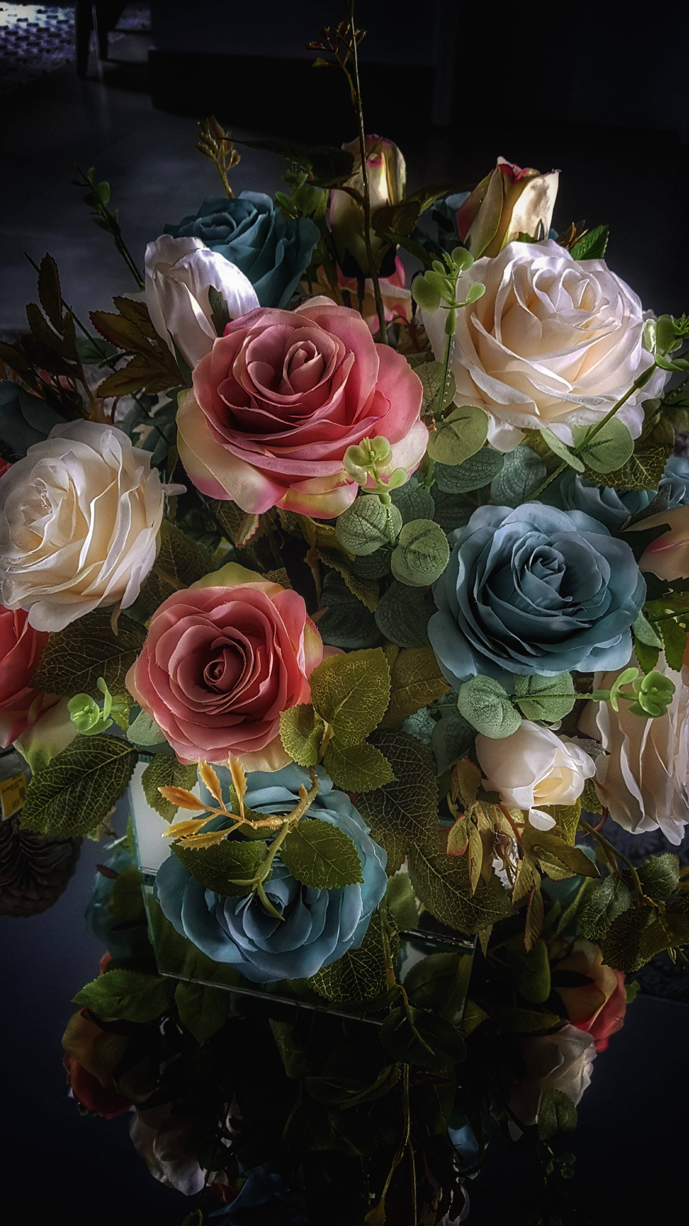 Roses 桌布 壁紙 — 一束戲劇性的粉紅、藍色和奶油色粉彩玫瑰在聚光燈下，在深色反光表面上閃耀。