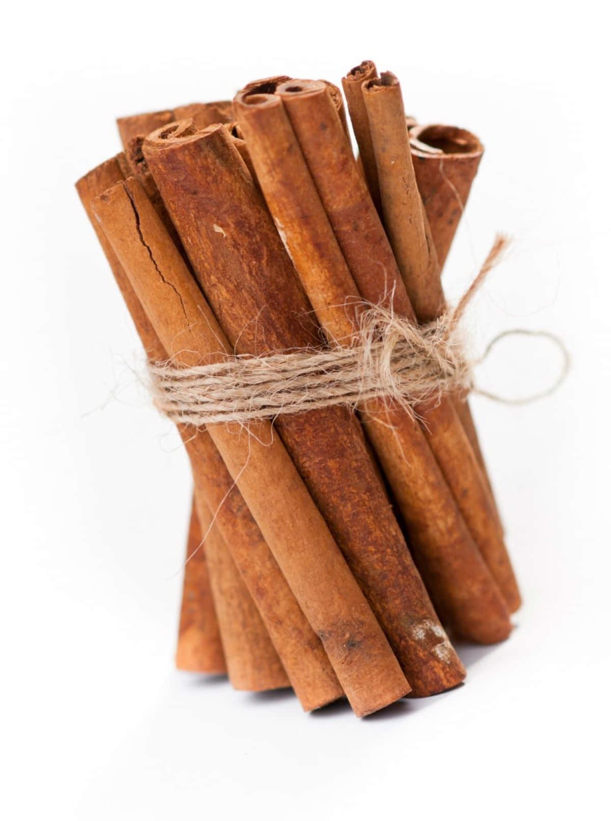 stick 桌布 壁紙 — 一束用麻繩捆紮的質樸肉桂棒，置於潔白背景上。