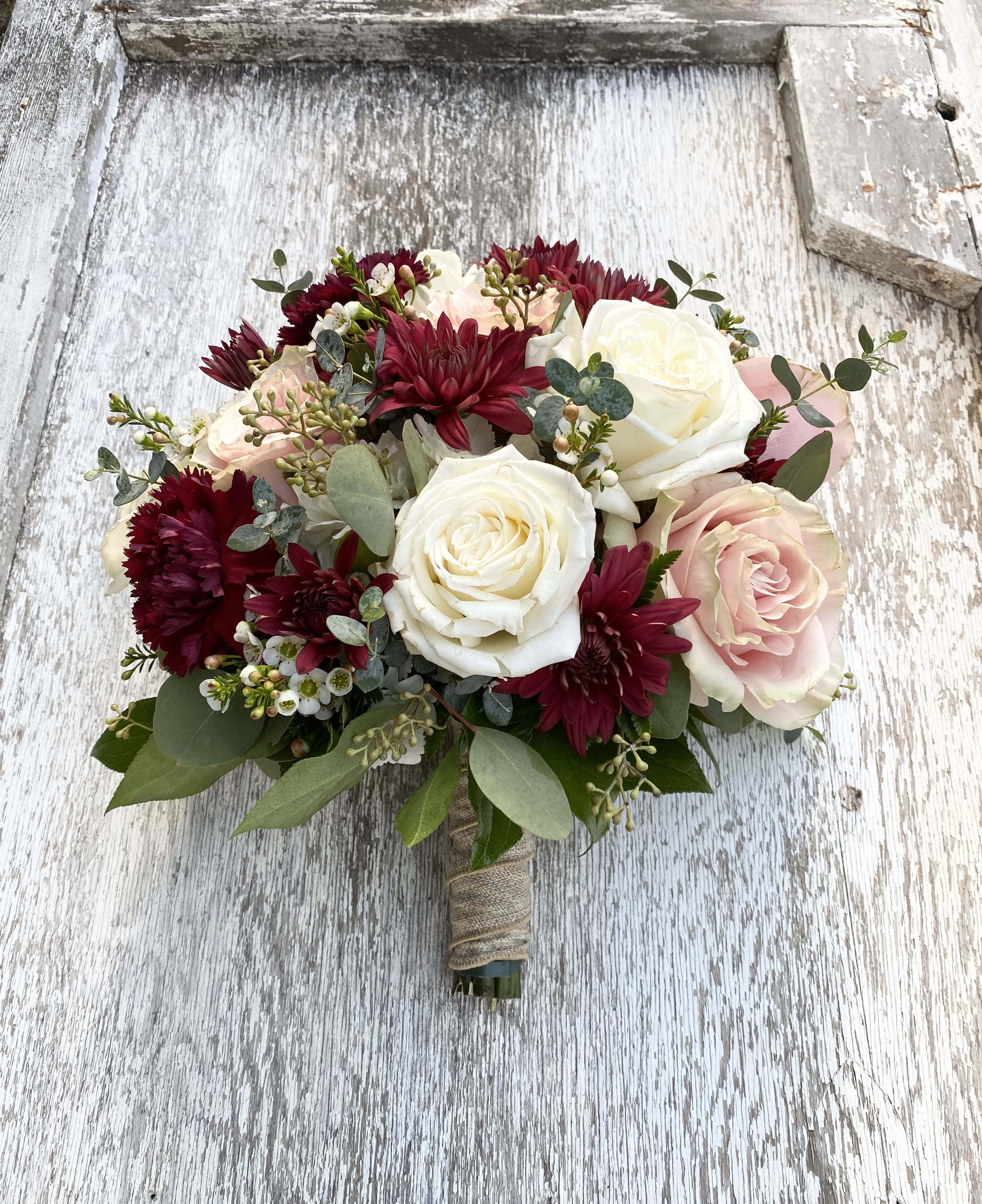 Roses Wedding 桌布 壁紙 — 一束由白色、粉紅色和酒紅色玫瑰及大理花組成的豐盛新娘花束，放置在一個風化的白色木質表面上。