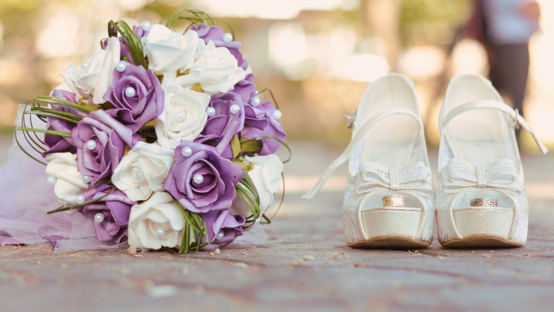 Wedding 桌布 壁紙 — 一束紫白玫瑰配珍珠點綴的新娘花束，放在石徑上優雅的白色婚鞋旁邊。