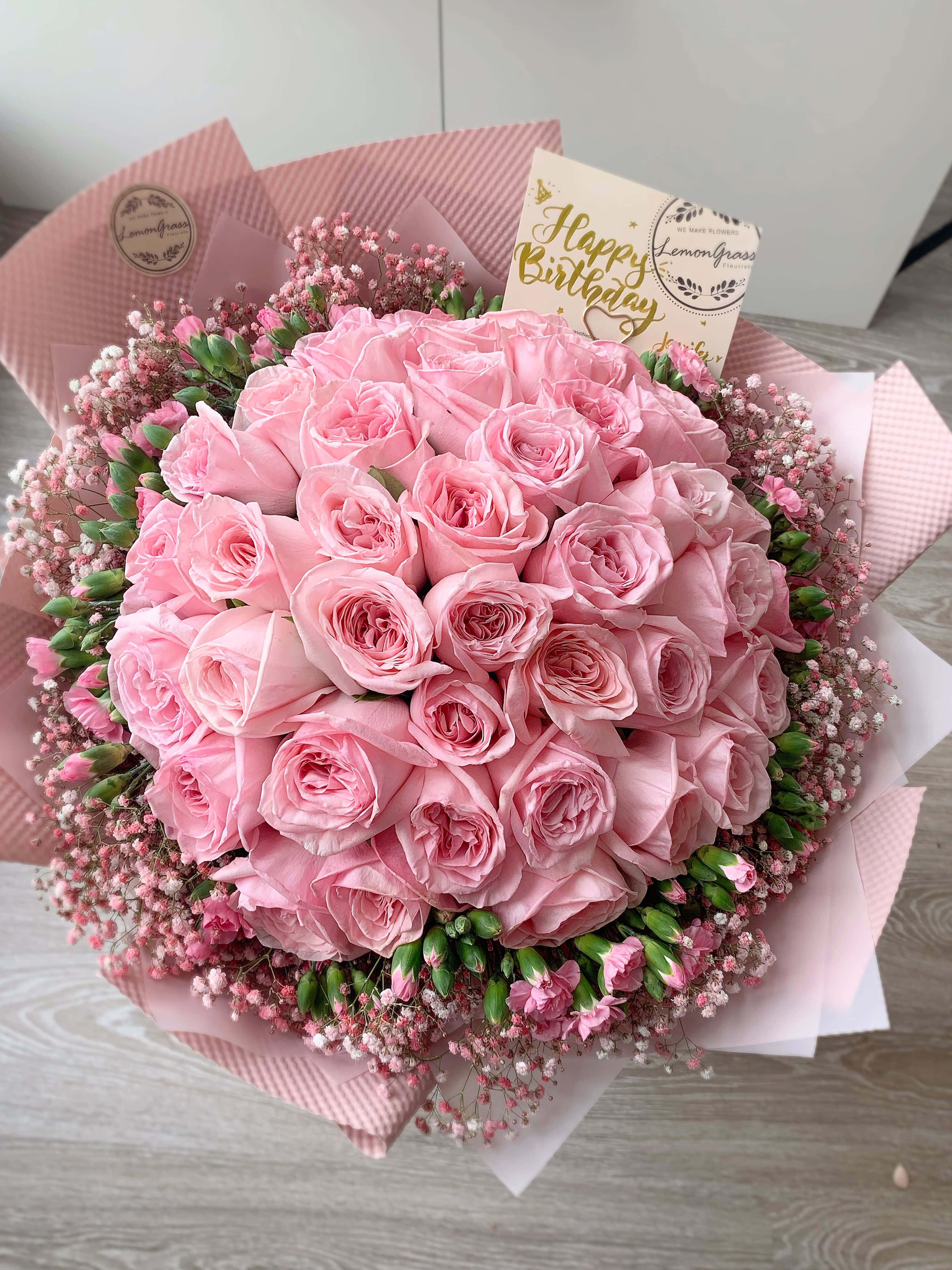 Flowers 桌布 壁紙 — 一束茂盛的粉紅玫瑰和滿天星，用粉紅紙包裝，附有「生日快樂」卡片。