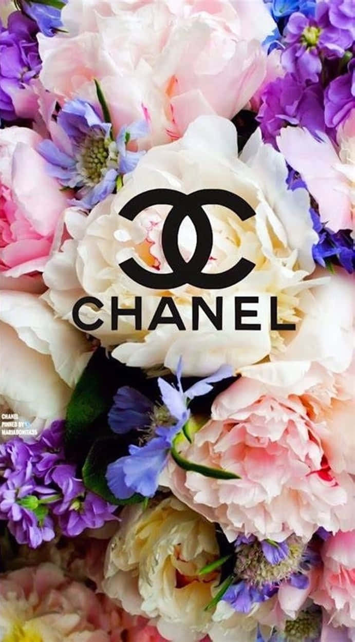 Chanel Aesthetic 桌布 壁紙 — 一束茂盛的粉紅色和紫色花朵，中央突出一個大膽的黑色 Chanel 標誌。