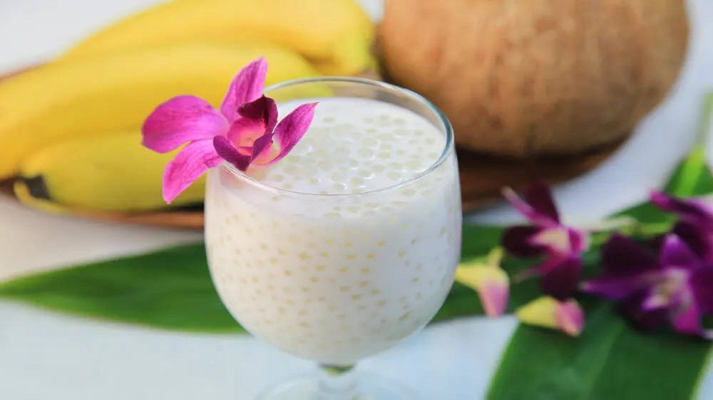 Fruit 桌布 壁紙 — 一杯 creamy 椰奶西米露甜品，以粉紅蘭花裝飾，旁邊有香蕉和椰子。