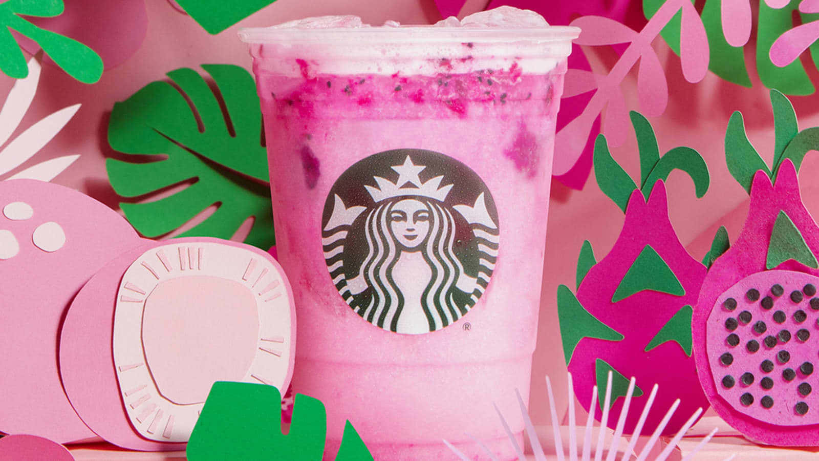 drinks 桌布 壁紙 — 一杯充滿活力的粉紅色星巴克星冰樂，內含火龍果粒，周圍環繞著色彩繽紛的剪紙熱帶樹葉和水果。