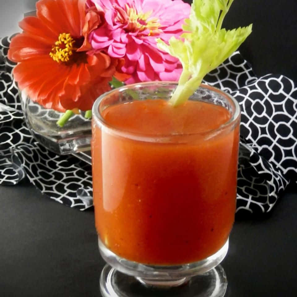 番茄飲品配芹菜裝飾，旁邊是圖案布上的色彩繽紛花朵。 — Juice Wrld 壁紙