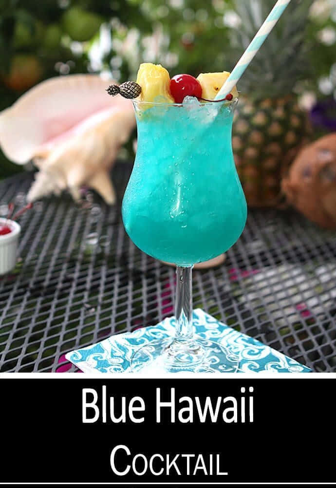 Blue Hawaii 桌布 壁紙 — 一杯充滿活力的藍色夏威夷雞尾酒，以鳳梨、櫻桃和鳳梨裝飾，置於熱帶戶外環境中。