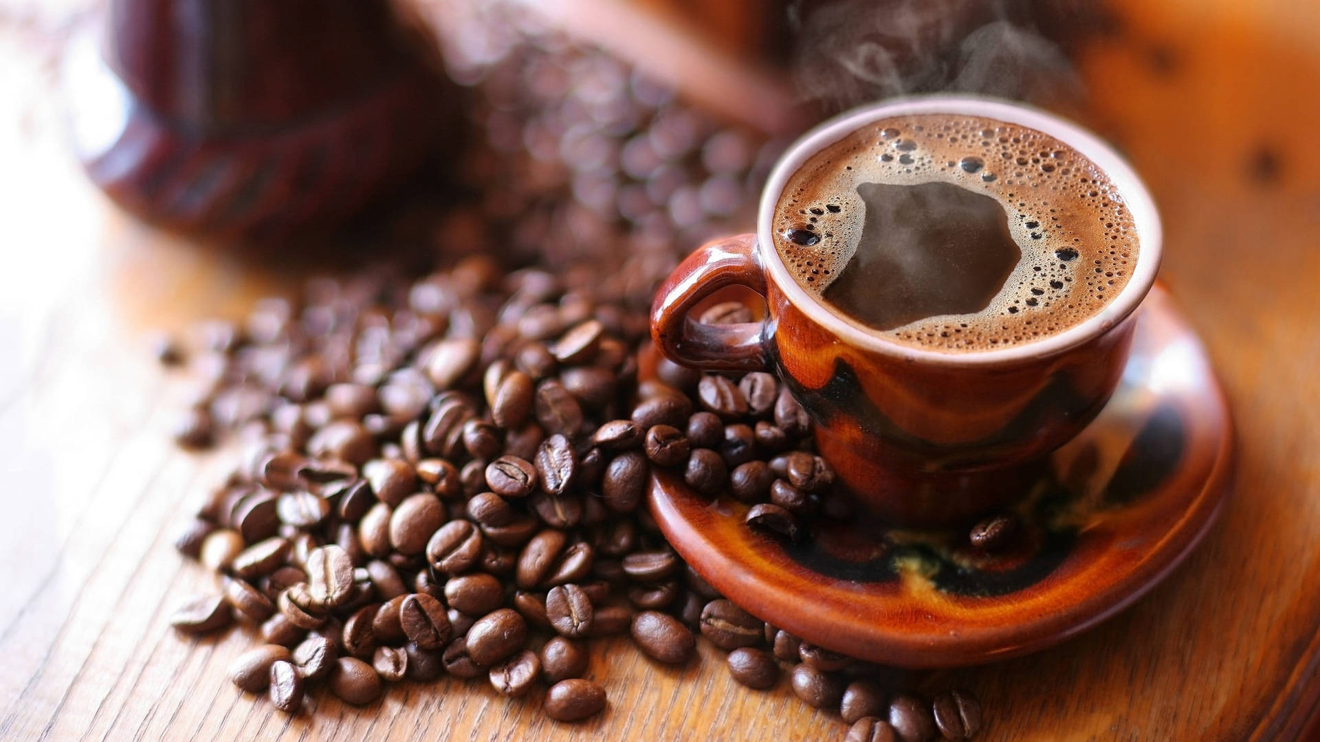 Coffee Aesthetic 桌布 壁紙 — 一杯冒煙的咖啡放在木桌上，周圍散落著烘焙過的咖啡豆。