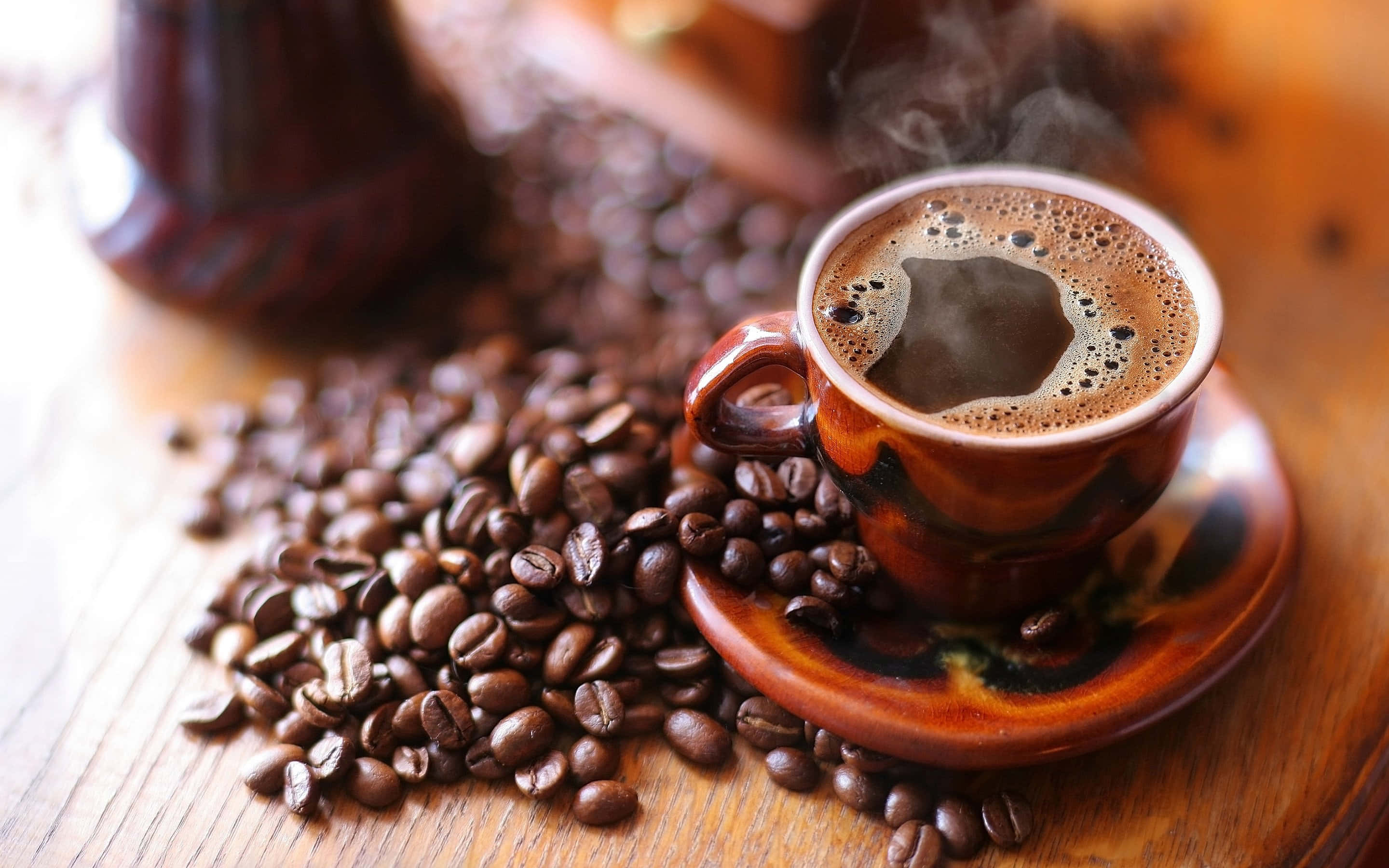 Black Coffee 桌布 壁紙 — 一杯冒煙的咖啡放在木桌上，周圍散落著烘焙咖啡豆。