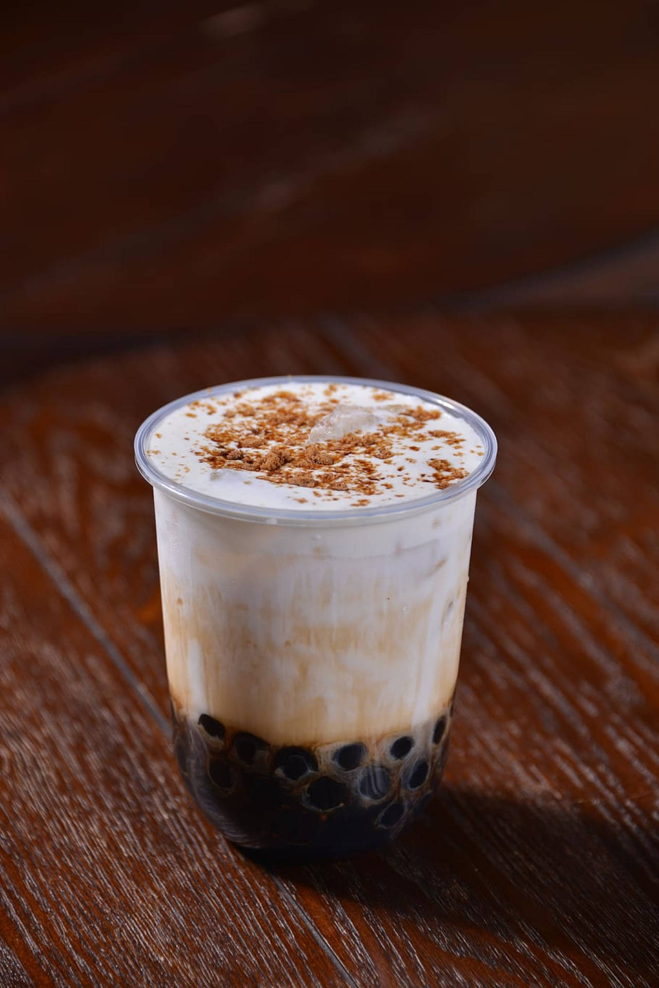 Bubble 桌布 壁紙 — 一杯奶油冰珍珠奶茶，上面有巧克力碎，放在透明杯中，置於深棕色木桌上。