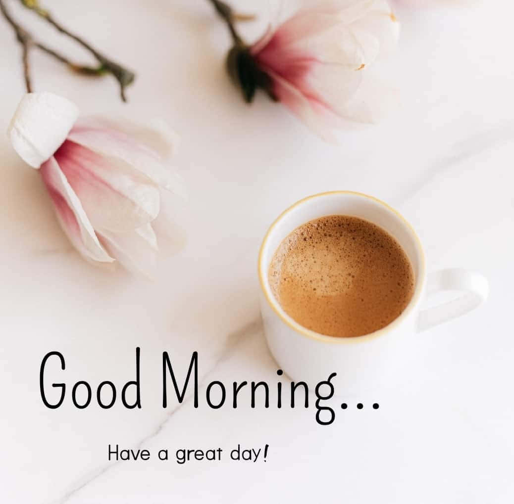 Good Morning 桌布 壁紙 — 一杯白色咖啡放在精緻的粉紅色木蘭花旁邊，大理石表面上帶有「早安」的問候語。