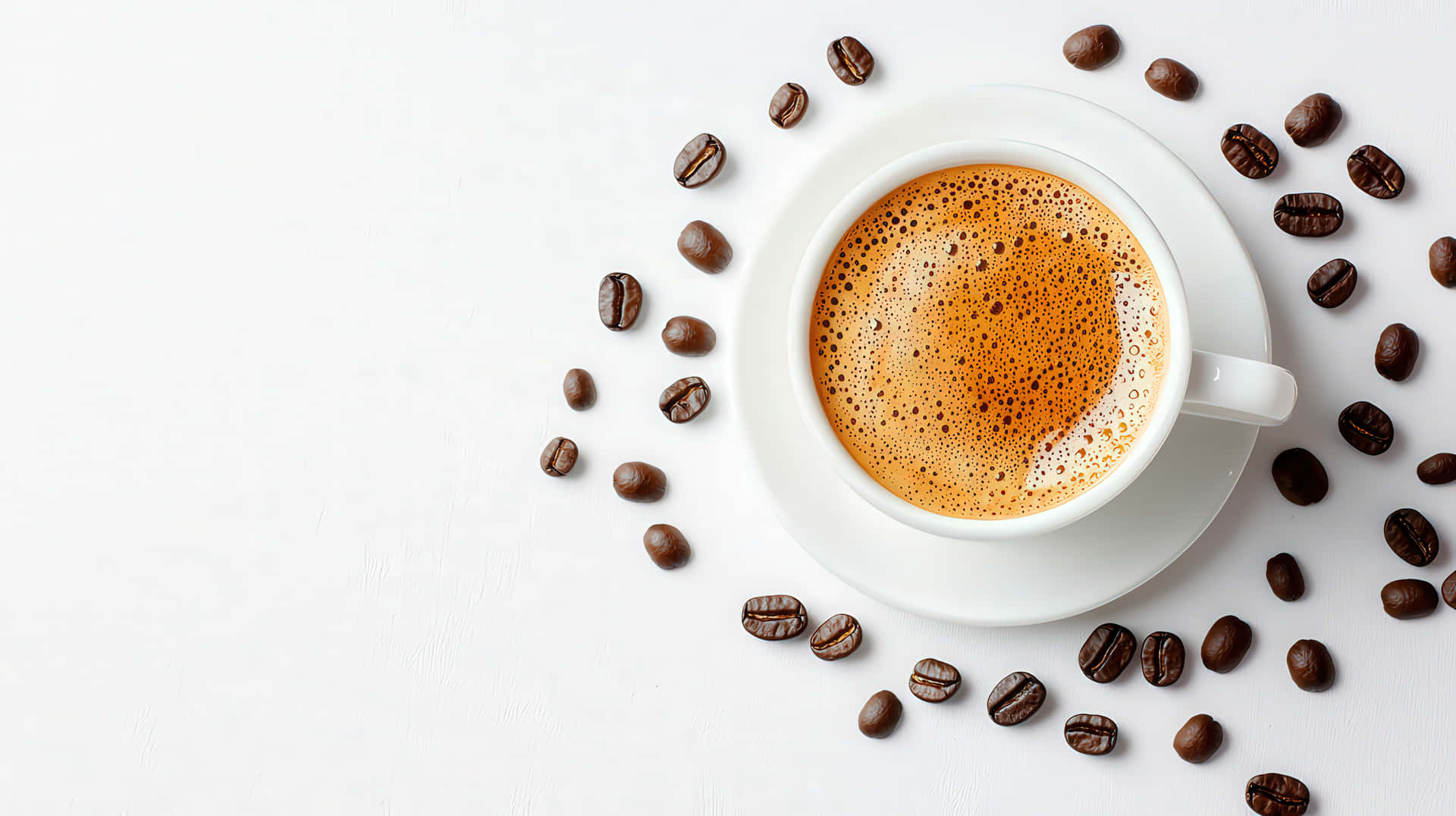 Freshly Brewed Coffee in a White Cup Surrounded by Roasted Coffee Beans on White Background 壁紙 — 一杯白色泡沫咖啡，周圍散落著深棕色咖啡豆，放在明亮的白色表面上。