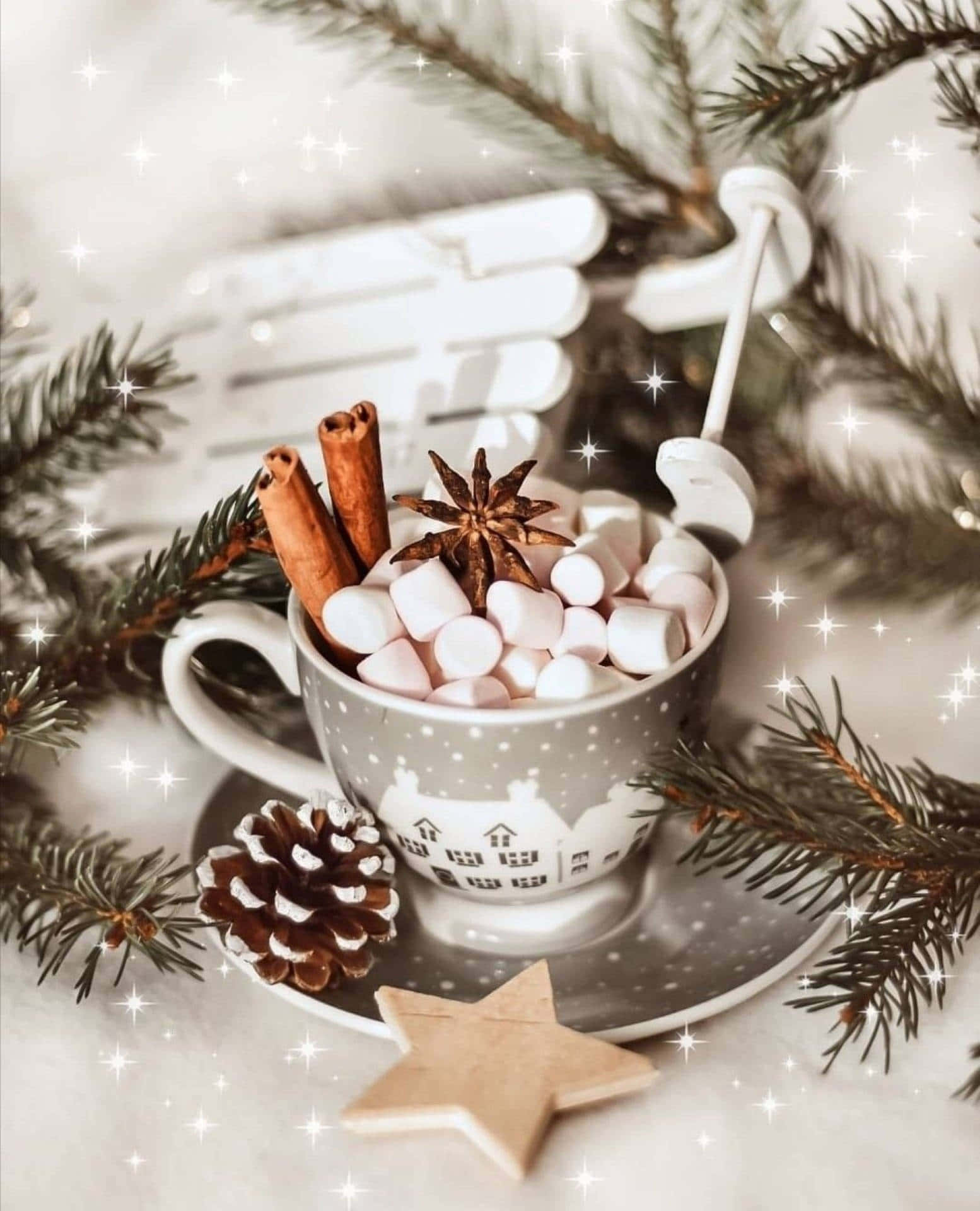 White Christmas iPhone 桌布 壁紙 — 一杯舒適的熱可可，配以棉花糖、肉桂棒和八角，藏在松樹枝和木星之間。