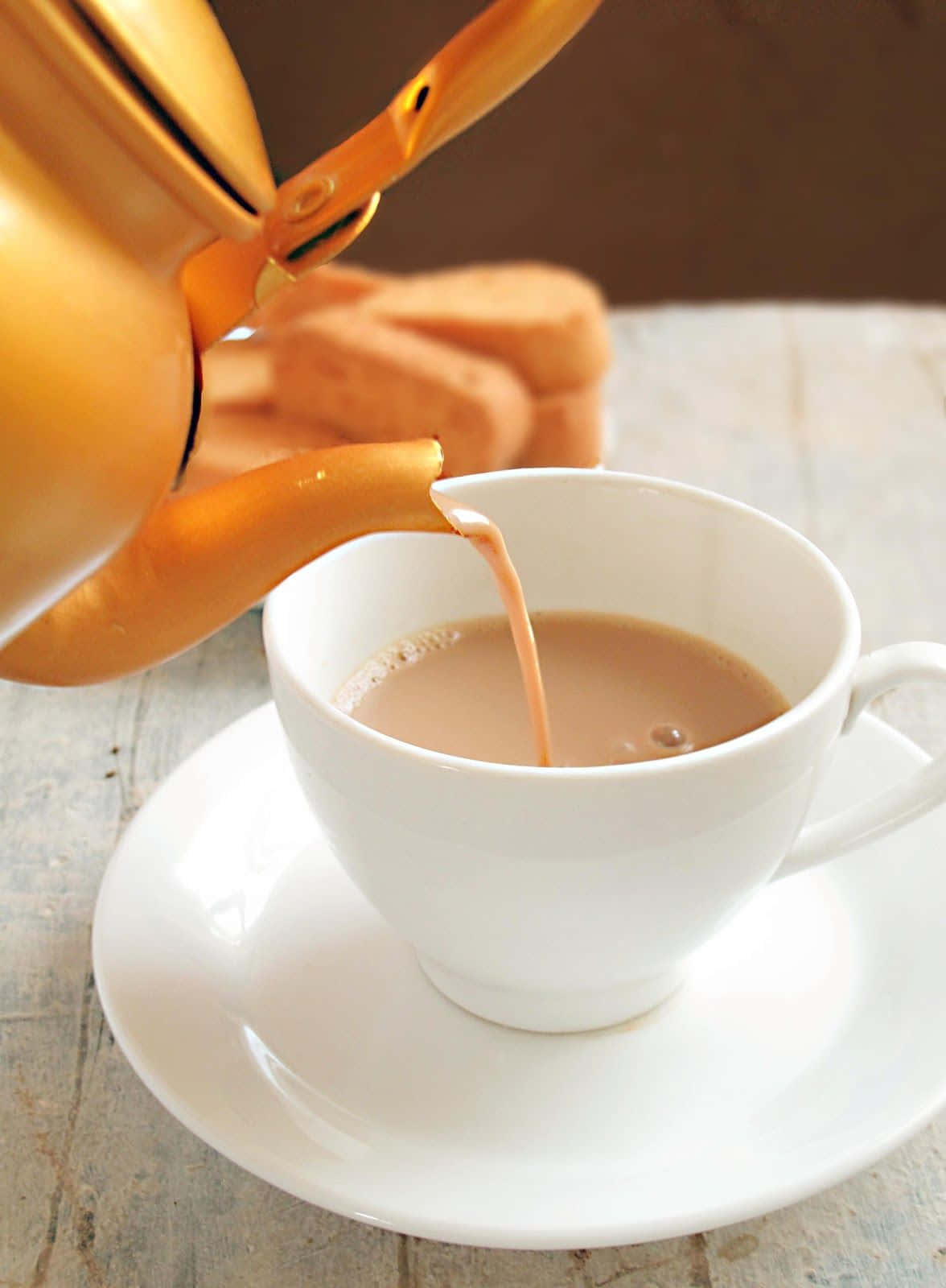 一杯茶正被倒入茶碟中 壁紙
